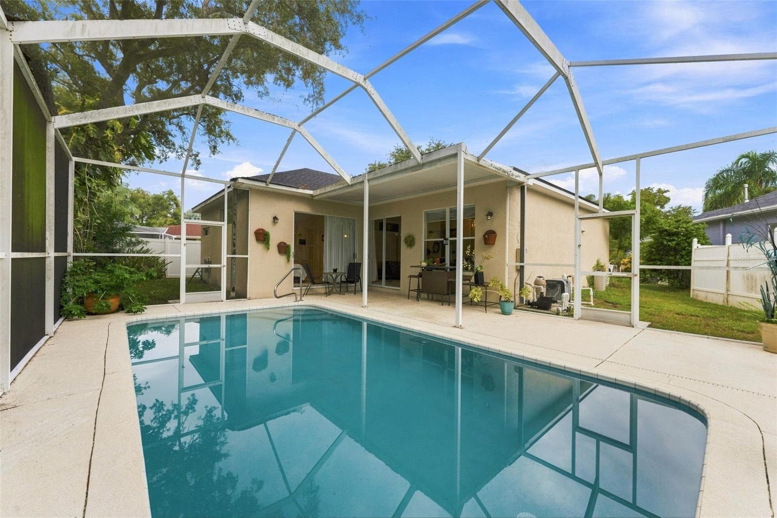 Tarpon Springs Pool Home, covered patio and large yard surrounding the space. - 491 BRILAND ST, TARPON SPRINGS