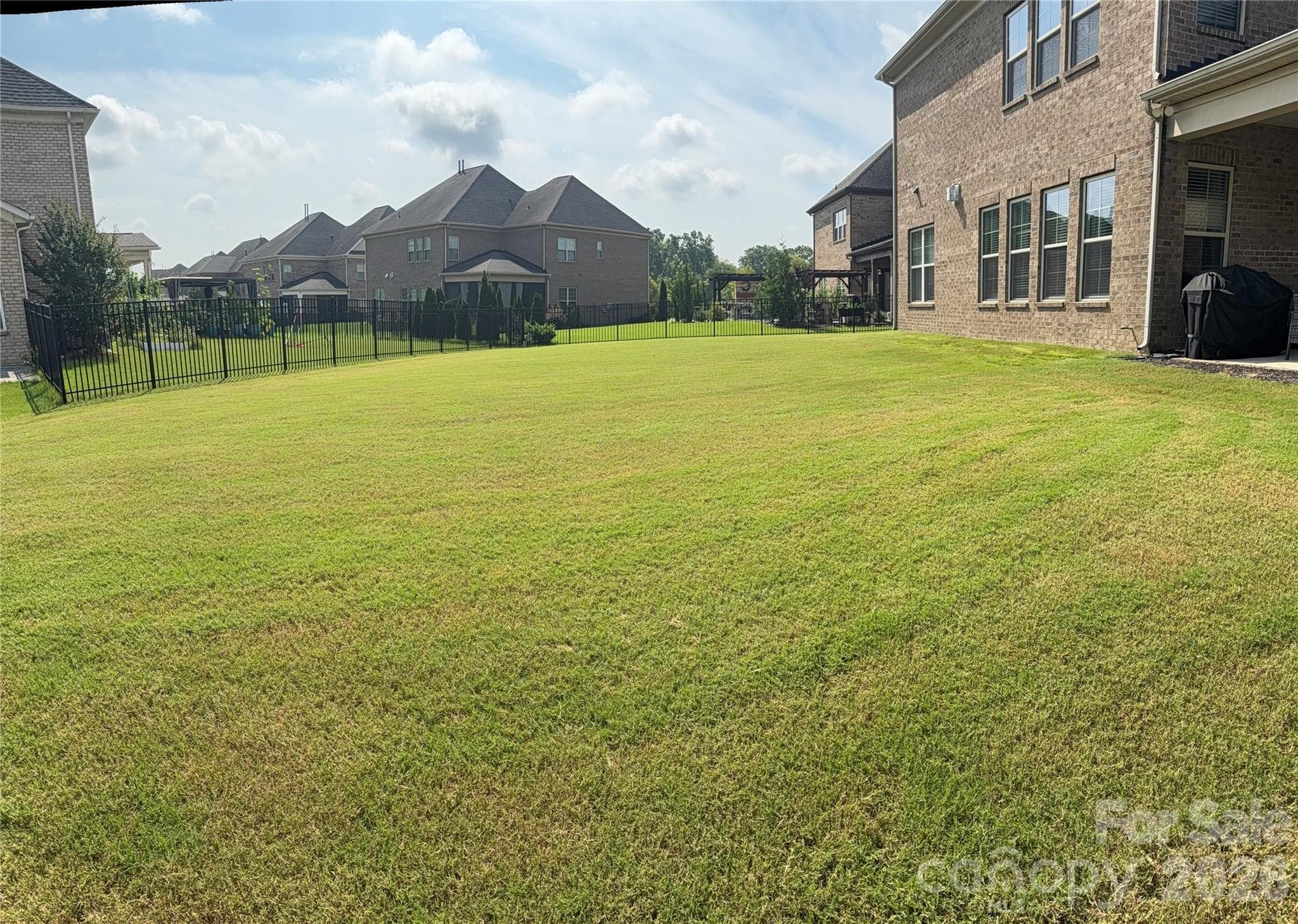 Spacious Backyard (alternate view) w/3 sided wrought iron fencing. Owner previously had invisible fencing where the open spacing is located. - 8465 Blume Parkway, Harrisburg