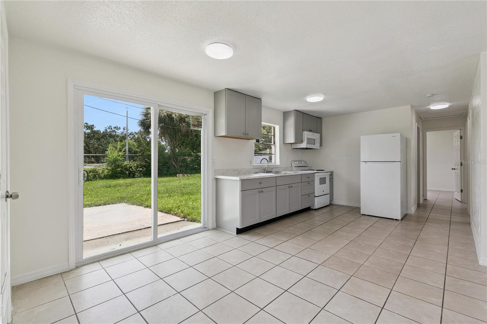 Kitchen with Patio Access - 875 LOOMIS AVE, DAYTONA BEACH