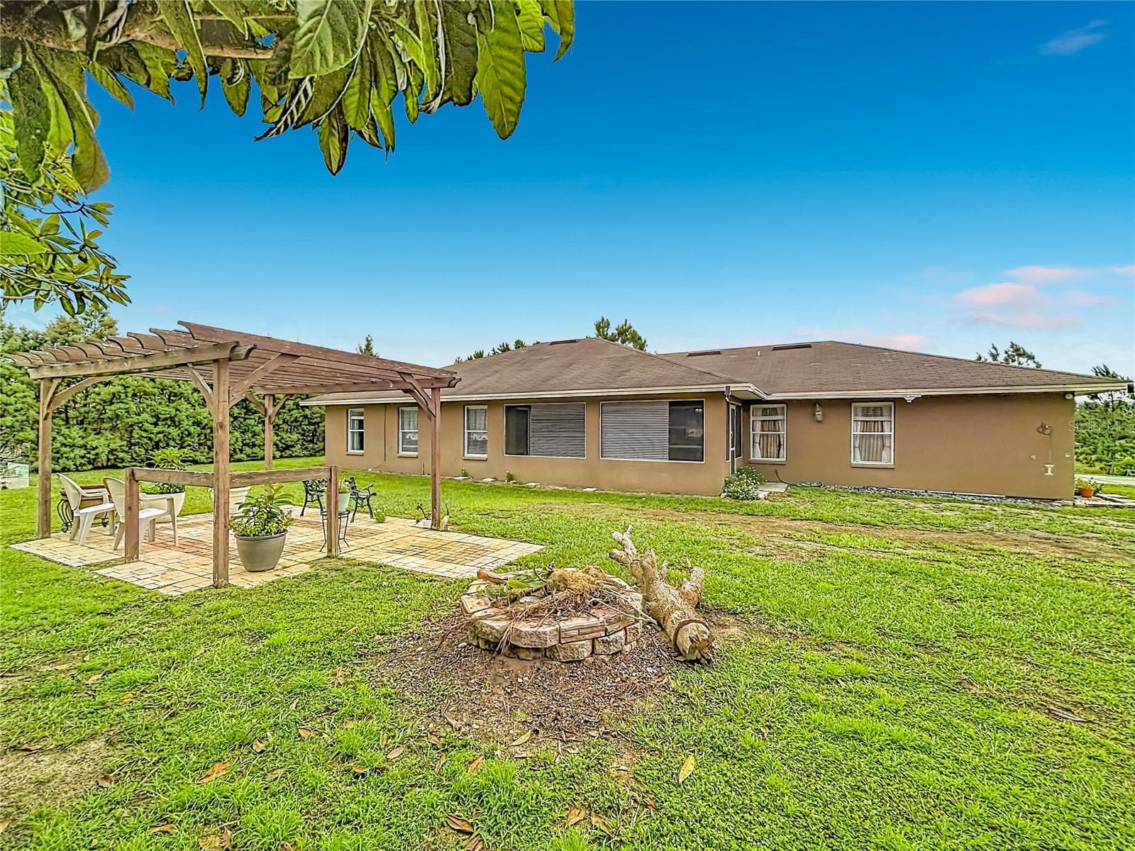 Pergola and spacious backyard area—perfect for barbecues, gatherings, and cozy evenings around a fire pit. - 18030 BAYAMON AVE, POLK CITY