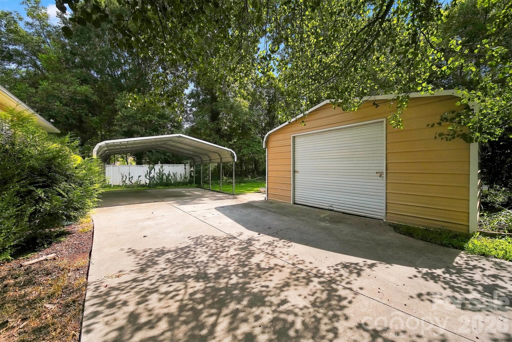 Side Yard with carport and detached garage - 717 2nd Street Place SW, Conover