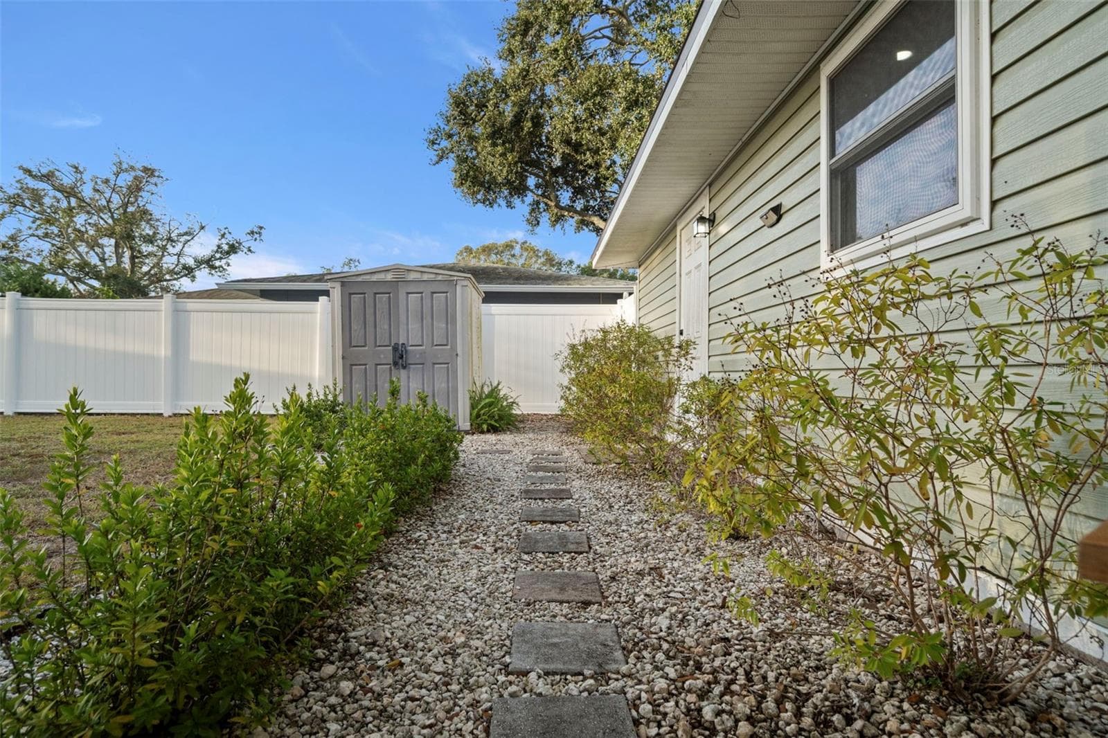 Walkway towards shed and back door access between kitchen and utility room leading to garage! - 6500 BRIAR RIDGE CT N, PINELLAS PARK