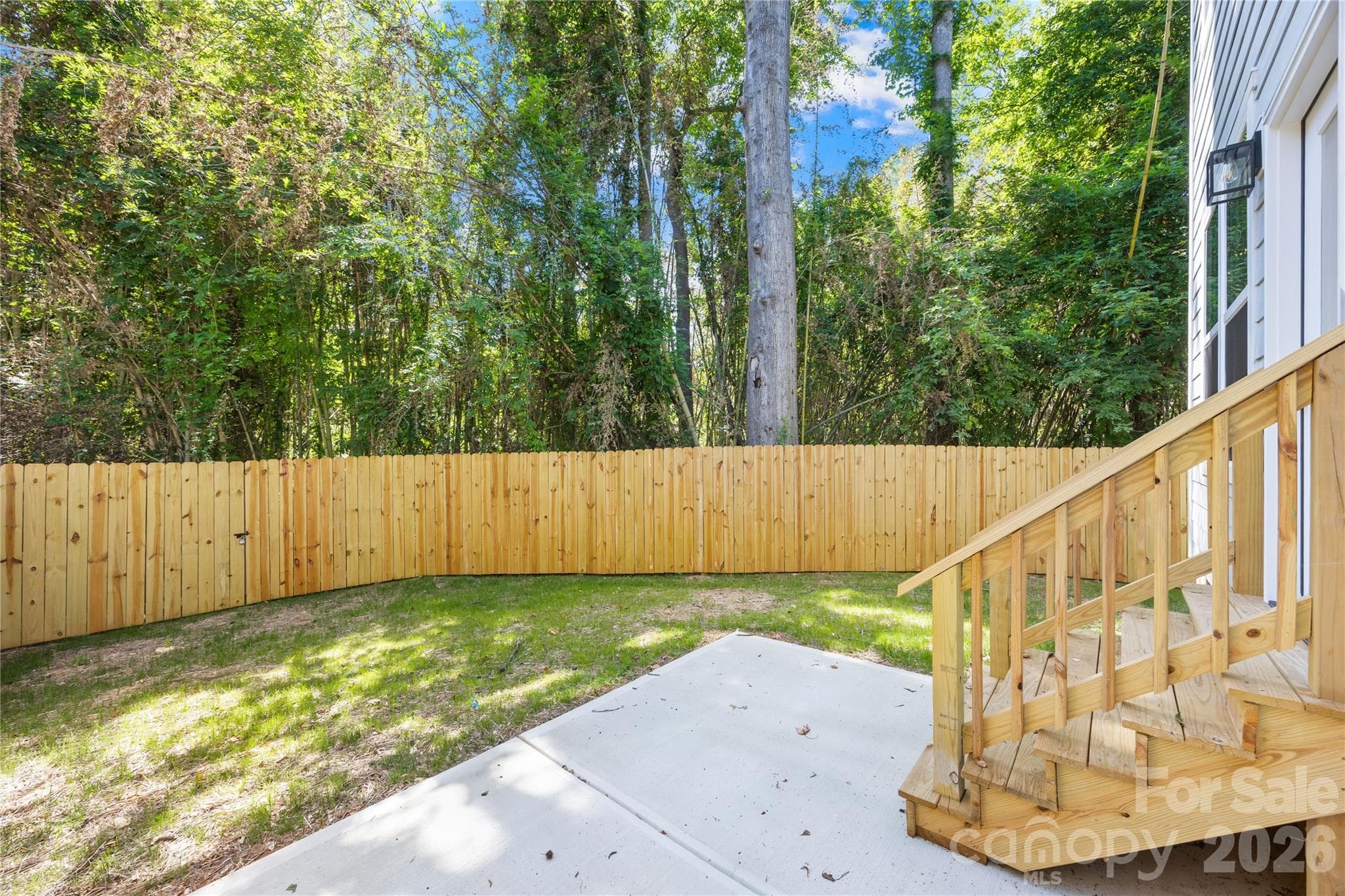 Fenced backyard with deck steps and room for outdoor seating and pets at 1940 Purser Dr, Charlotte - 1940 Purser Drive, Charlotte