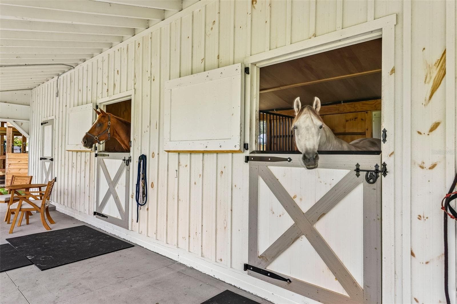 Dutch-style stall doors with durable metal top trim designed to help prevent horses from chewing the wood. - 2088 NW 102ND BLVD, WILDWOOD
