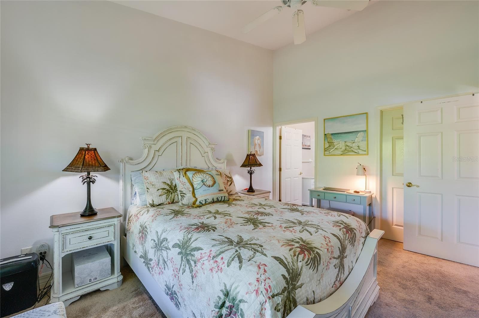 Well-proportioned bedroom with high ceilings, neutral carpet, and soft wall colors. Open doorways lead directly into an en-suite bathroom and a private closet. - 1413 COCONUT PALM CIR, PORT ORANGE