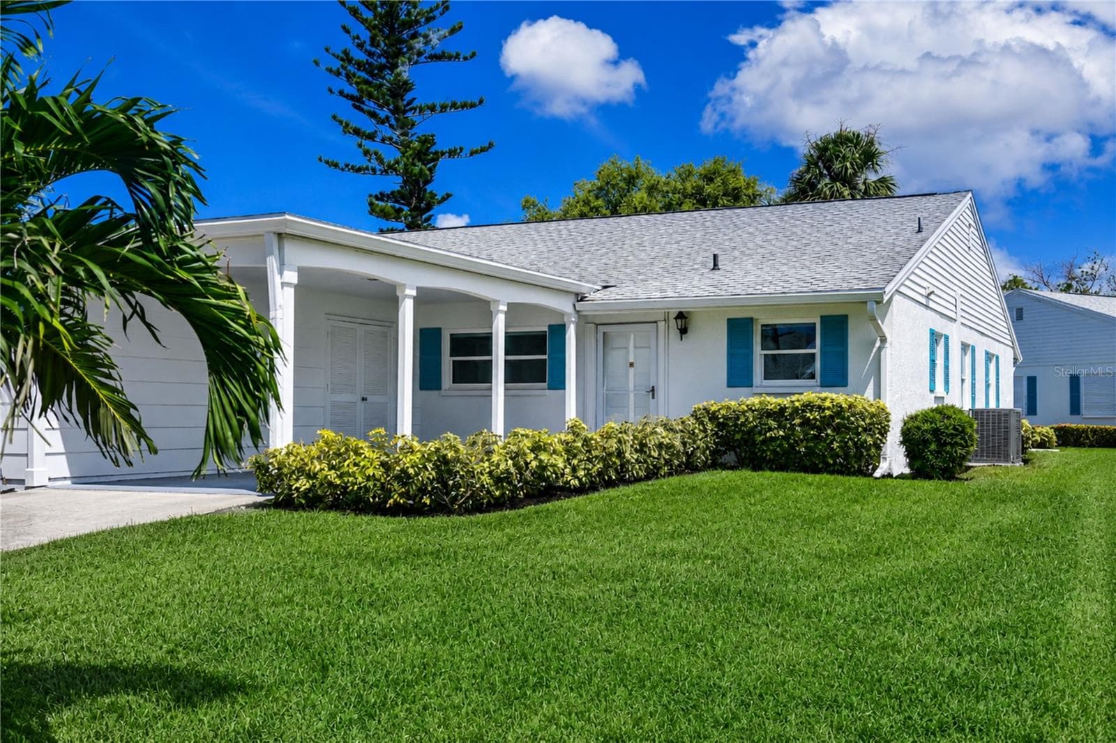 Front of villa with carport, driveway, & secure storage - 9411 CONCORD CIR, BRADENTON