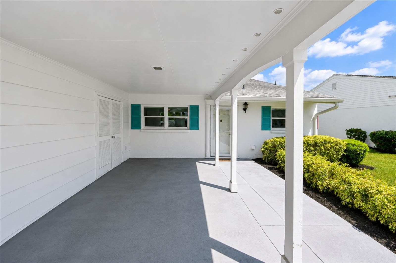 Private attached carport doubles as shaded front porch and patio - 9411 CONCORD CIR, BRADENTON