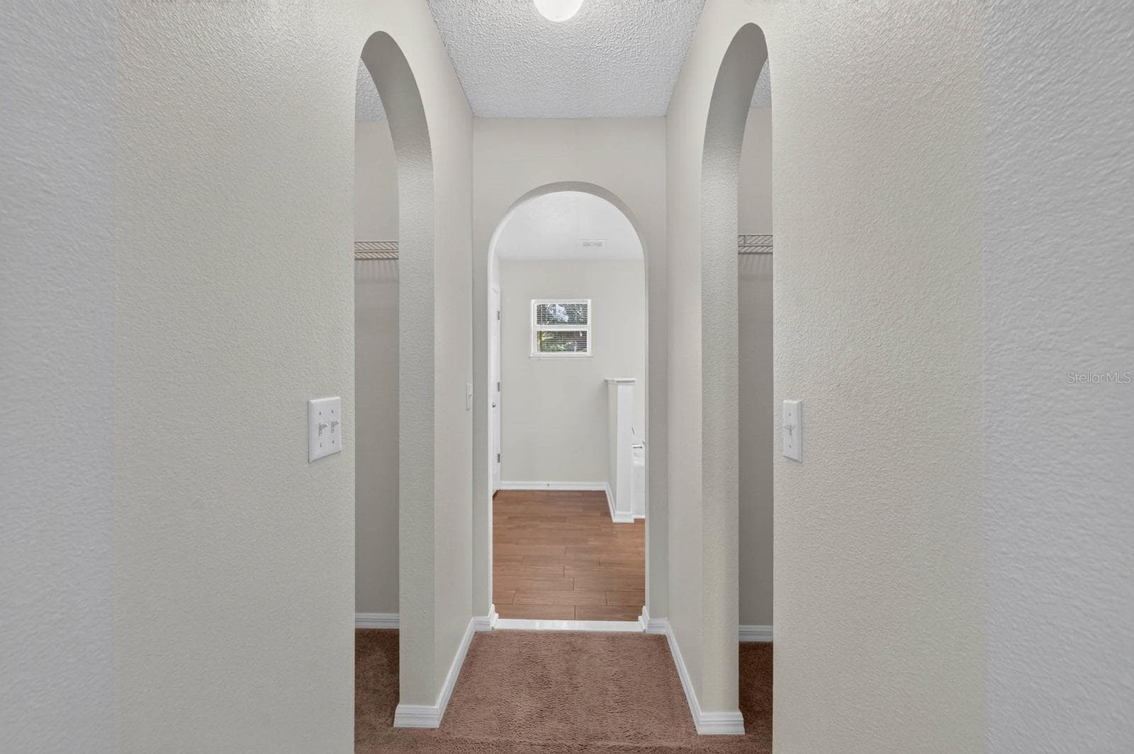 primary bedroom looking towards ensuite bath with his and her closets on either side before the bathroom - 99 PICKERING DR, PALM COAST