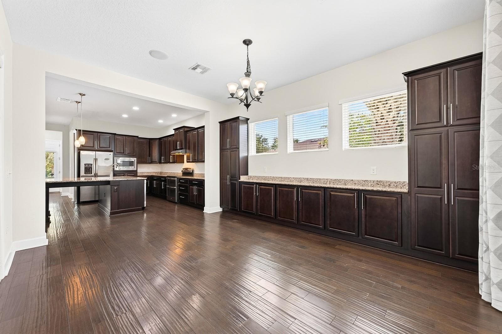 The rich cabinetry extends from the kitchen into the dining room for endless storage. - 8130 LAUREATE BLVD, ORLANDO