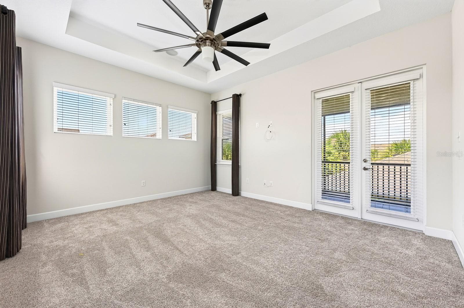 French doors off the primary suite open to a private balcony. - 8130 LAUREATE BLVD, ORLANDO