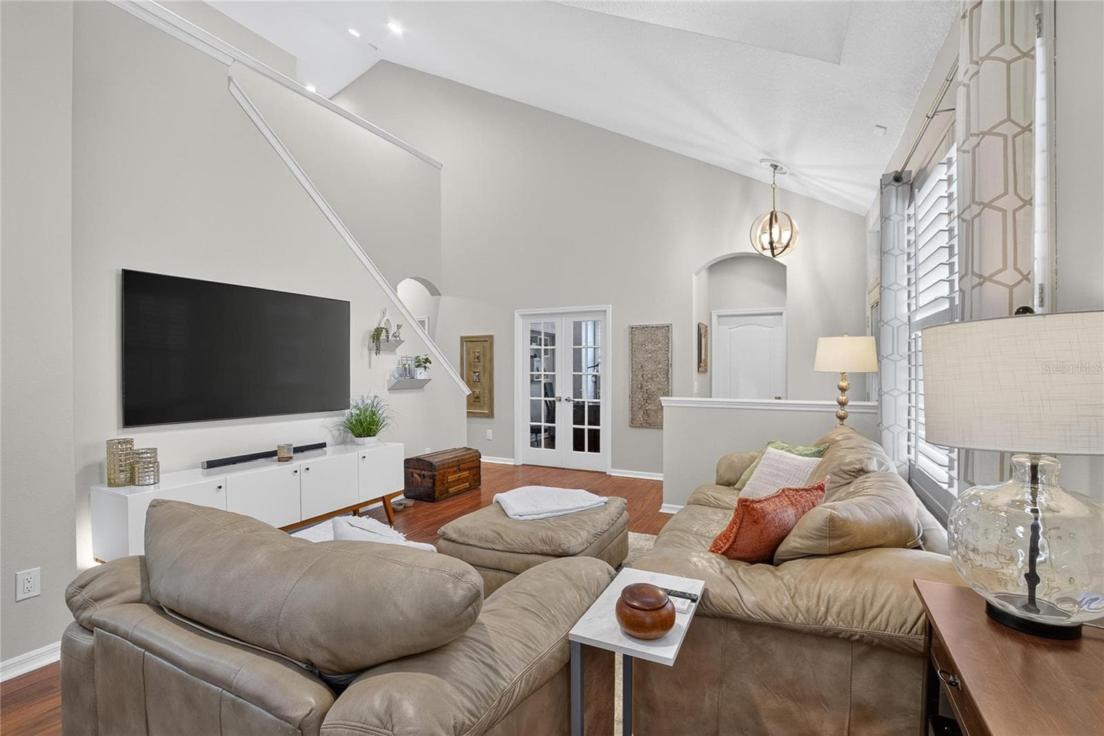 Spacious living area with soaring ceilings, abundant natural light and French doors leading to the private den. - 10807 SIERRA VISTA PL, TAMPA