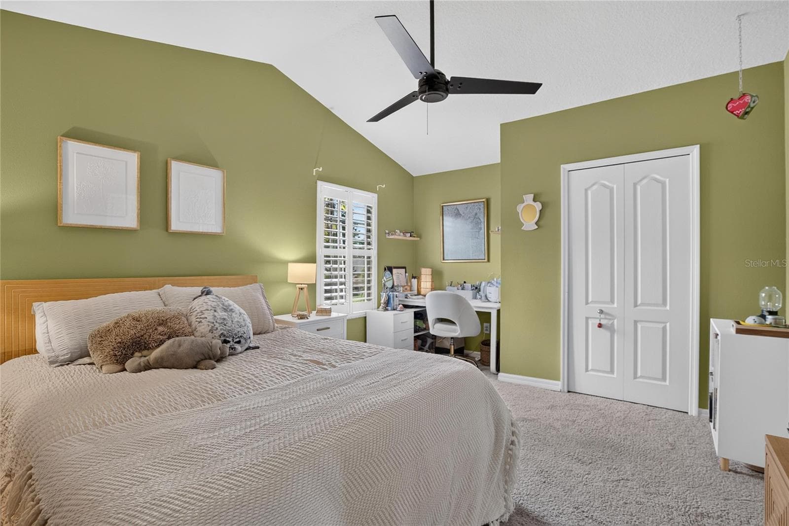 Vaulted ceiling and plantation shutters add character and natural light to this spacious secondary bedroom. - 10807 SIERRA VISTA PL, TAMPA