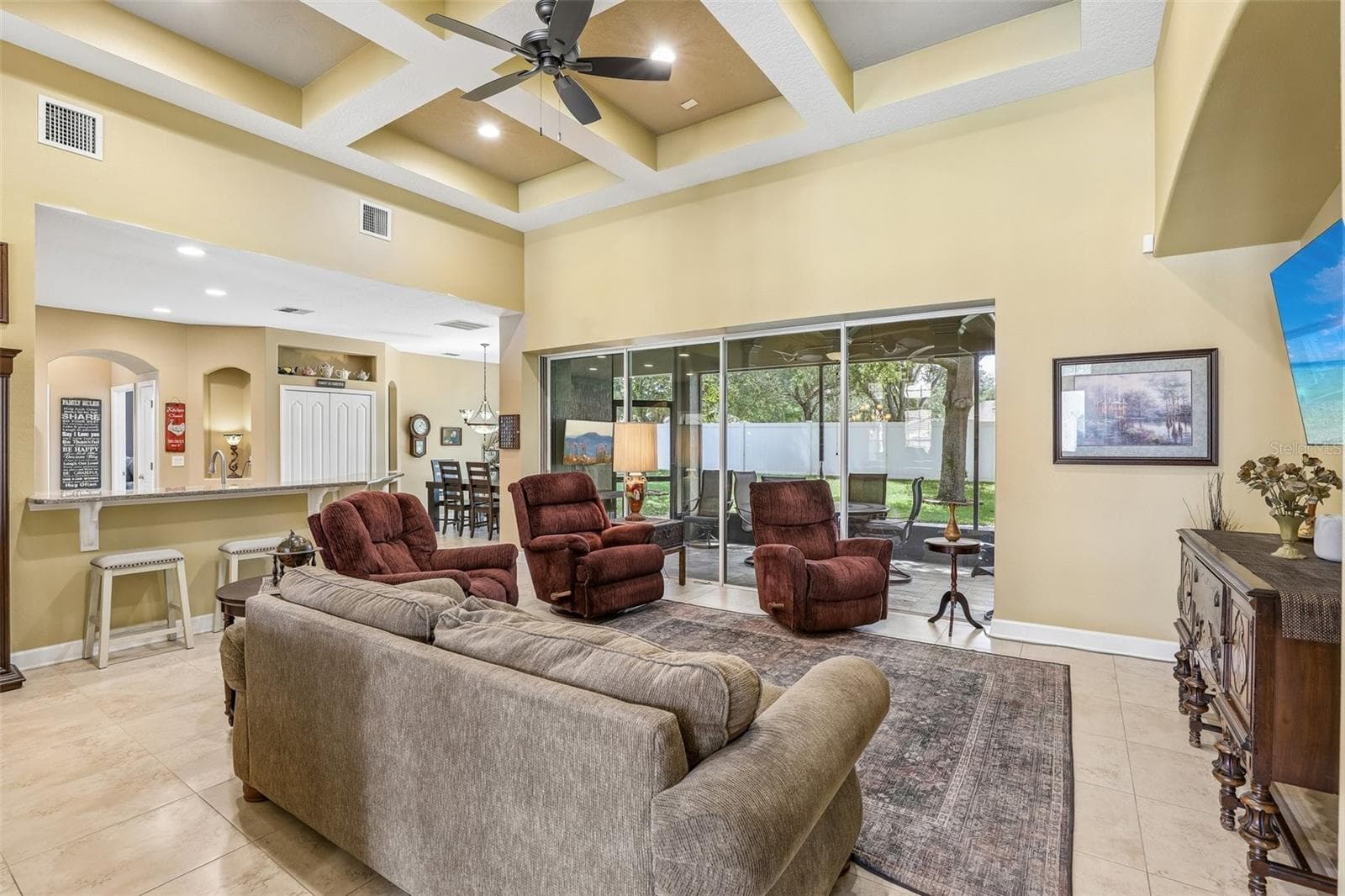Family room is open to the kitchen with a wall of sliding glass doors that open to the lanai. - 2431 PONKAN SUMMIT DR, APOPKA