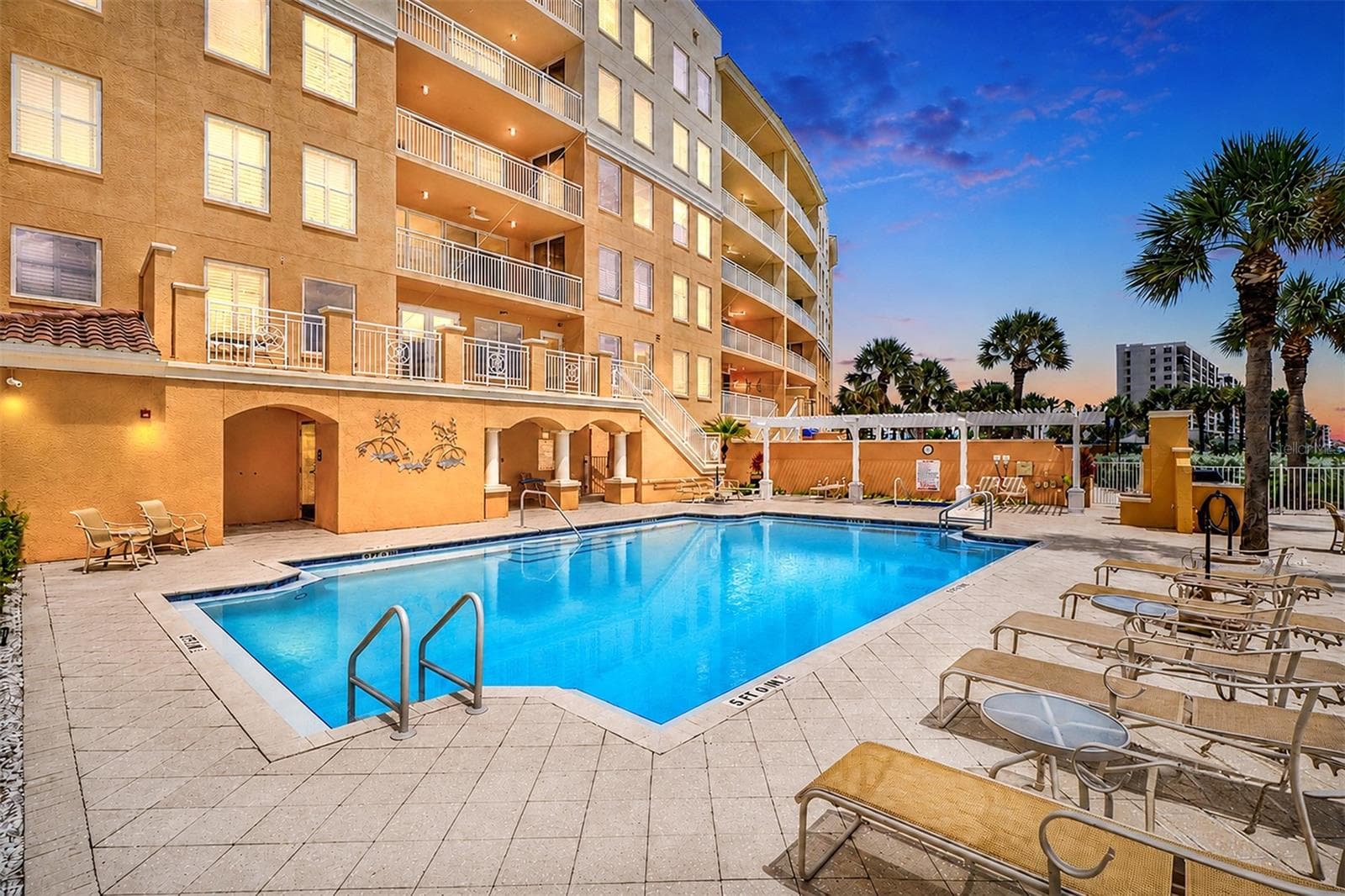 ... Night Shot of Pool & Spa Area at the Sereno..  NOTE: The Stairs From the Pool Area to the 2nd Floor Landing has Clubhouse and Workout Facility Access. There are also Two Restrooms. The Large Pool Area Affords Numerous Lounging Areas.. Heated Spa Located on Far End After Pool. Shot to Right.. - 15208 GULF BLVD #404, MADEIRA BEACH