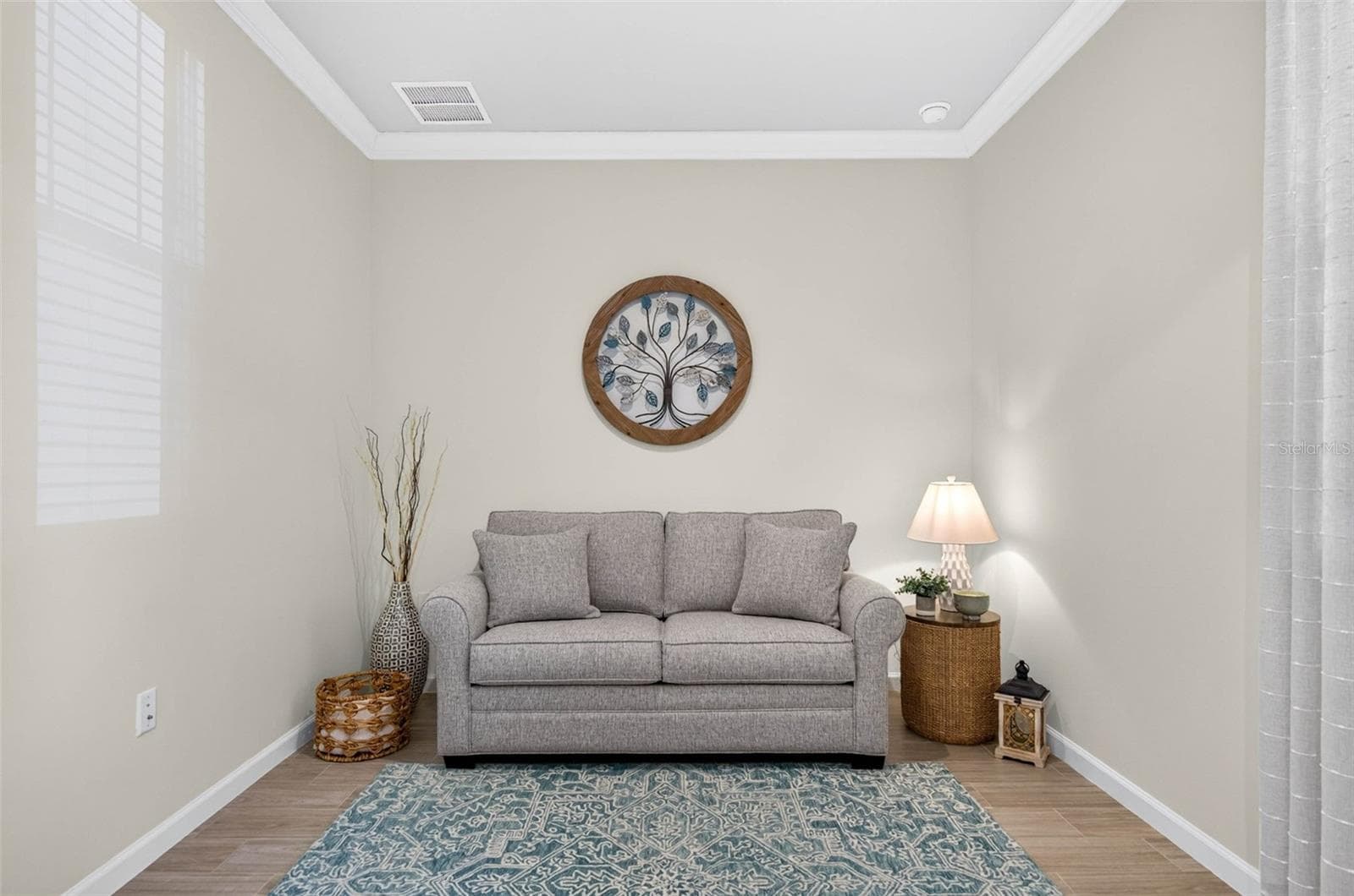 Den accented with wood-like tile flooring and crown molding in ceiling - 864 SNAIL KITE PL, SUN CITY CENTER