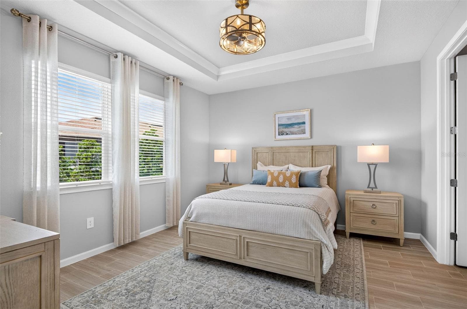 Primary suite with crown molding in trey ceiling and an elegant fandelier - 864 SNAIL KITE PL, SUN CITY CENTER