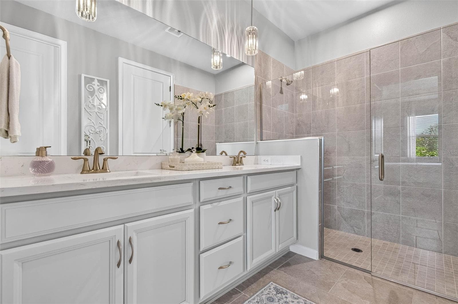 Long vanity with double undermount sinks, bank of drawers and elegant lighting - 864 SNAIL KITE PL, SUN CITY CENTER