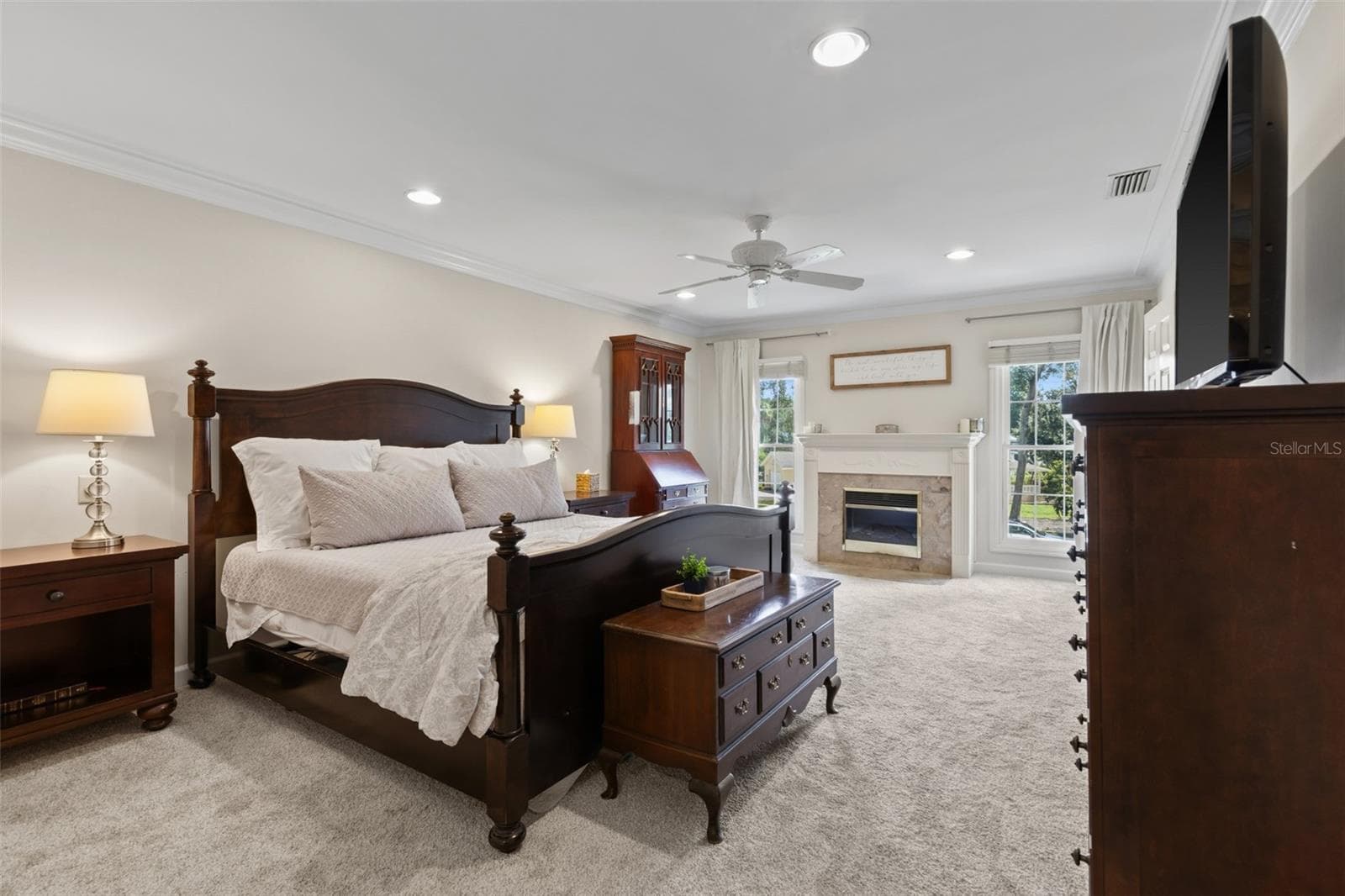 The Primary Bedroom is spacious and features crown molding, overhead lighting, an electric fireplace with mantle, and brand new carpet in Sept 2026. - 4603 DOGWOOD HILLS CT, BRANDON