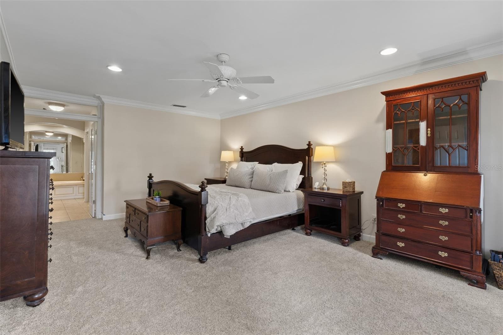 The Primary Bedroom is spacious and features crown molding, overhead lighting, an electric fireplace with mantle, and brand new carpet in Sept 2026. - 4603 DOGWOOD HILLS CT, BRANDON