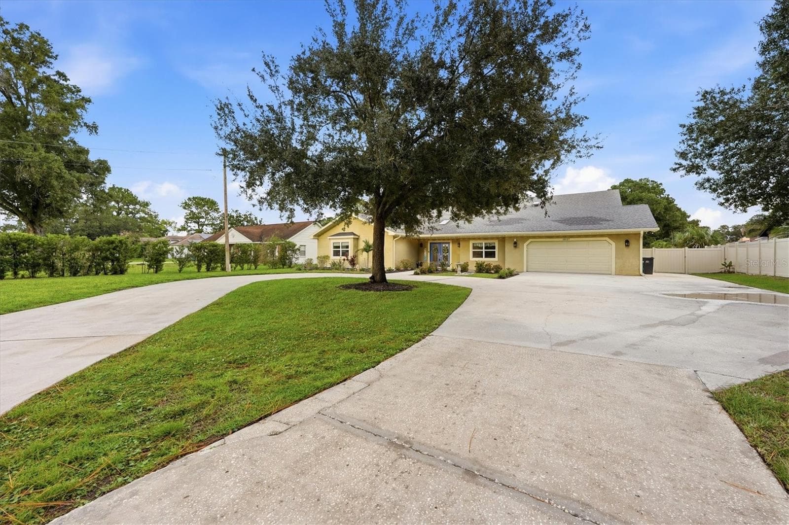 Oversized driveway offers a large parking pad to the right for storing an RV, boat or larger vehicle without blocking the garage. - 15127 PENNINGTON RD, TAMPA