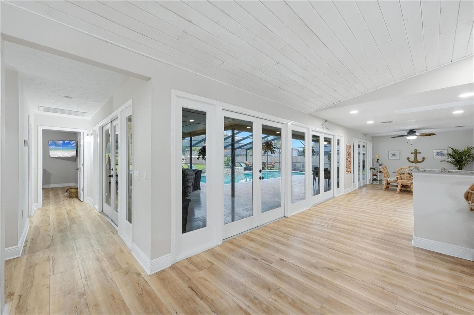 Wall to wall French Doors & windows provide clear view to pool and patio!  Hallway leads to bedroom 4 and adjoining full bath. - 15127 PENNINGTON RD, TAMPA
