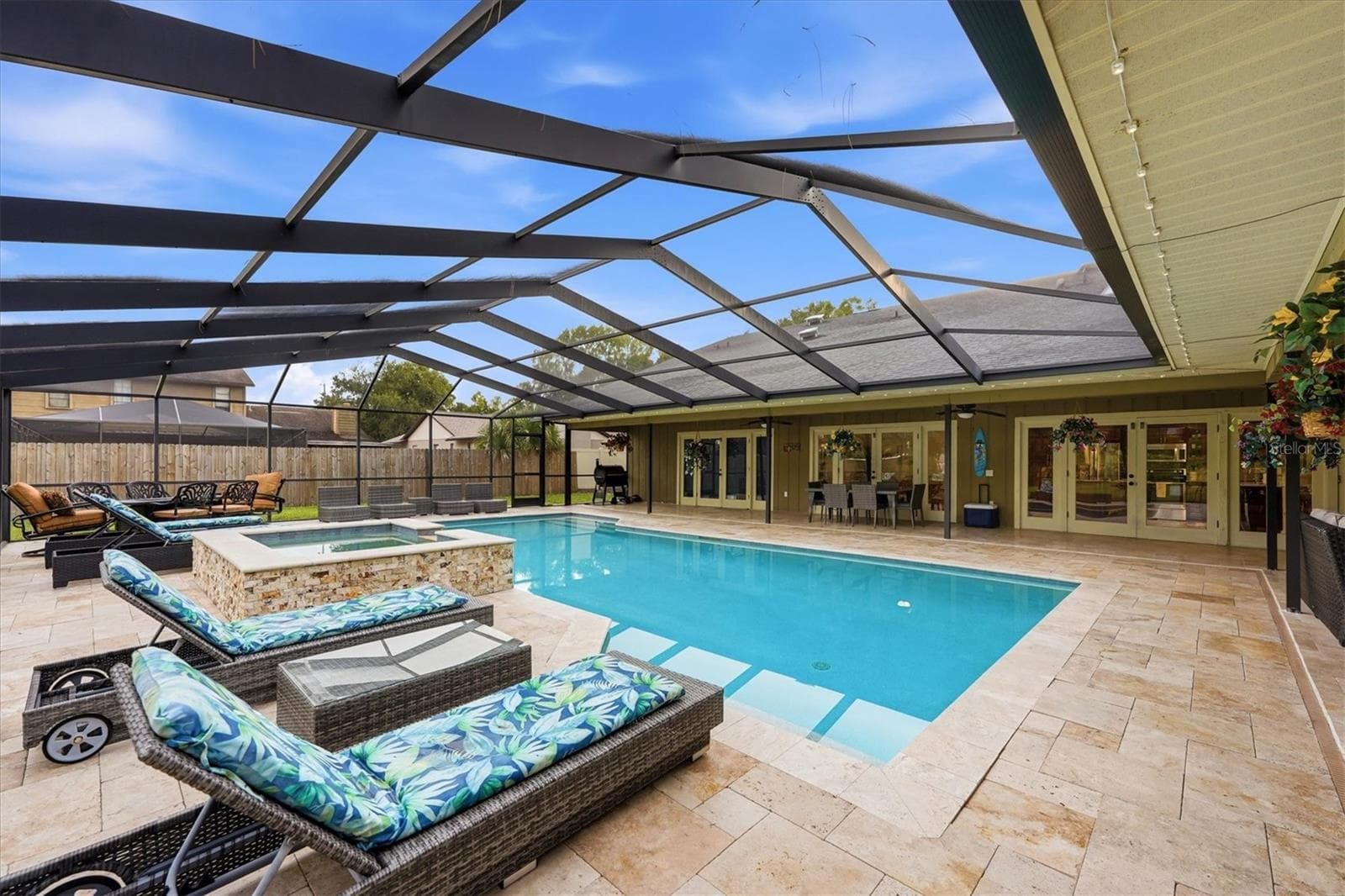 Inviting oversized pool with elevated spillover spa and plenty of seating for guests - 15127 PENNINGTON RD, TAMPA
