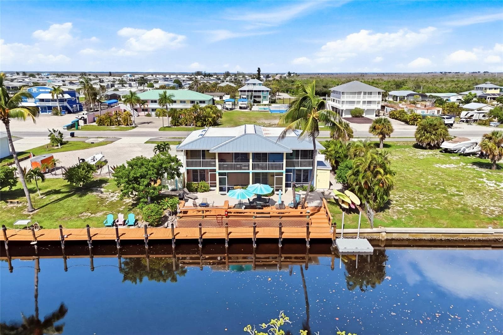 The expansive waterfront deck creates an inviting gathering space for guests to relax, entertain, enjoy beautiful sunsets, and watch for dolphins along the canal. - 3226 STRINGFELLOW RD, ST JAMES CITY