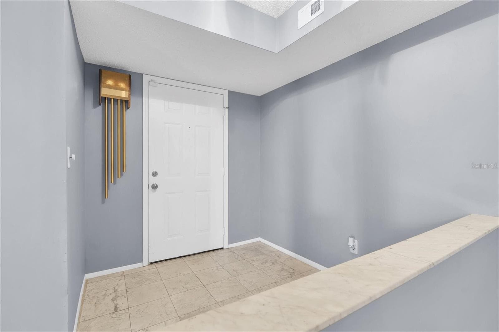 Interior entryway inside the unit with half wall looking into the dining room and open living area. - 8198 TERRACE GARDEN DR #511, ST PETERSBURG