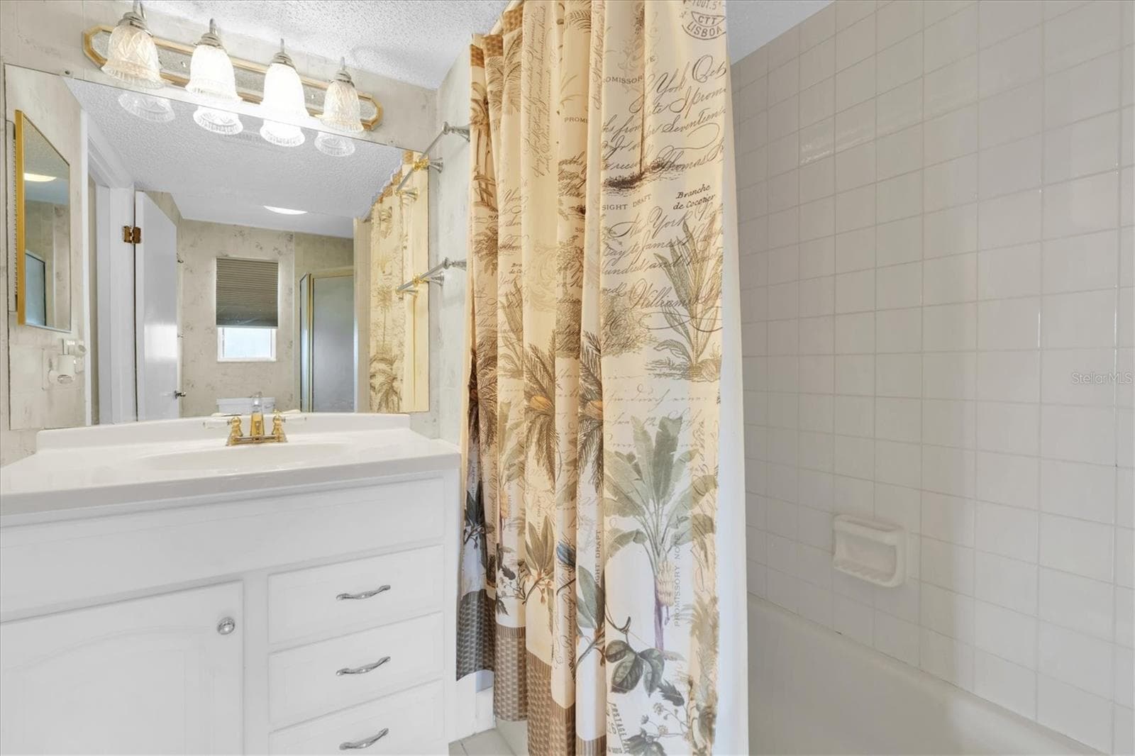 En suite bathroom with a bathtub and vanity - 8198 TERRACE GARDEN DR #511, ST PETERSBURG