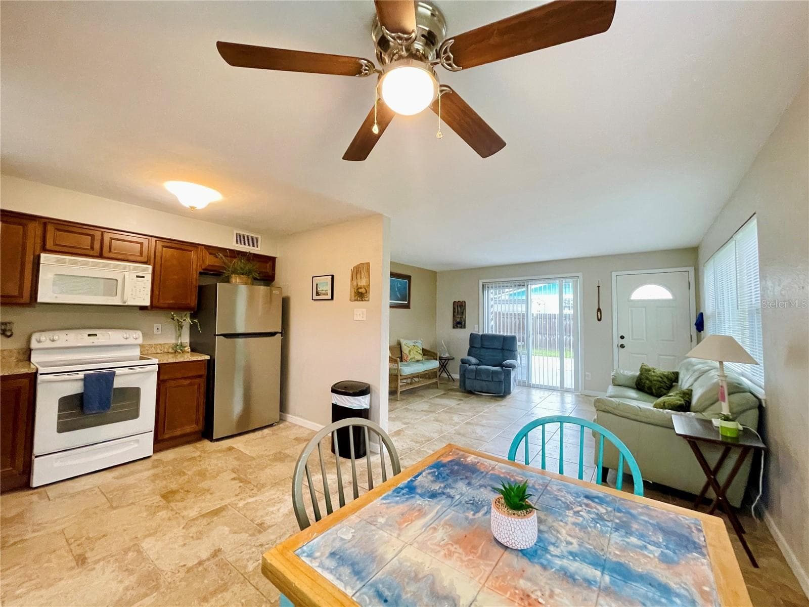 Multi-angle view of the functional kitchen and dining area, illustrating a fluid connection to the main living space for effortless entertaining. - 723 STEELE AVE, SOUTH DAYTONA