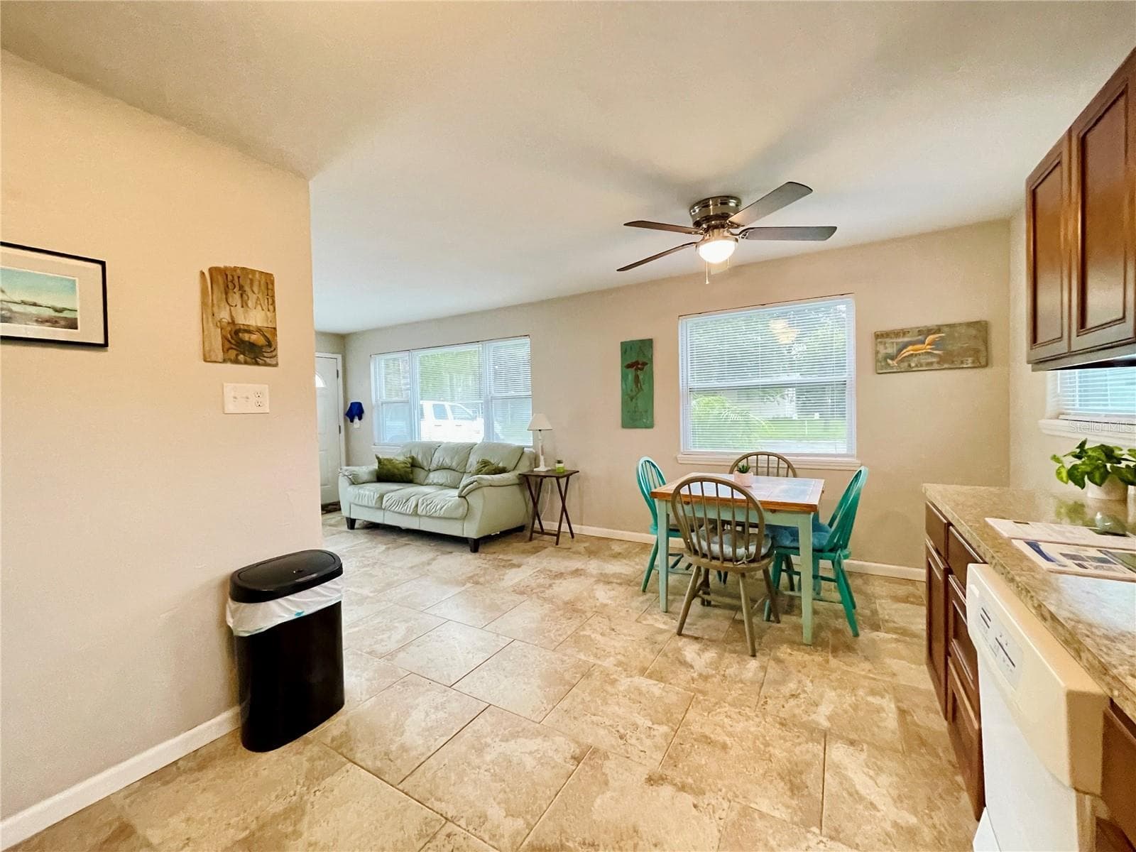 The kitchen and dining area flow naturally into the adjacent living space, creating an open, connected layout with multiple windows providing plenty of natural light. - 723 STEELE AVE, SOUTH DAYTONA