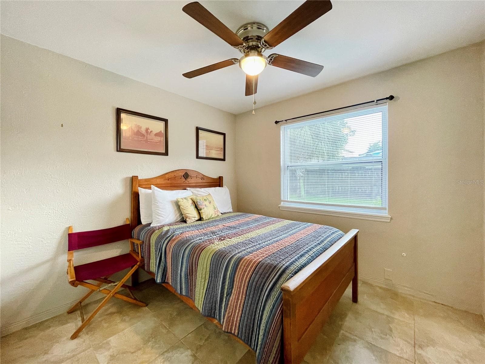 Cozy bedroom featuring a ceiling fan and large window. - 723 STEELE AVE, SOUTH DAYTONA