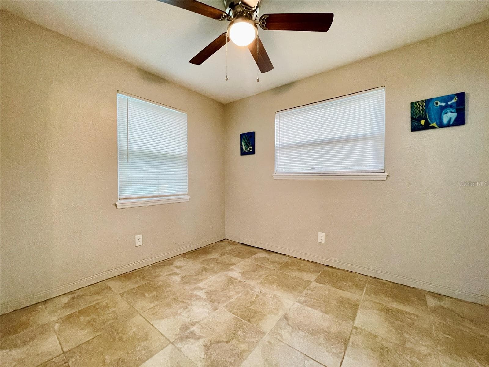 Natural light from two windows brightens this versatile guest bedroom, complemented by a ceiling fan for added comfort. - 723 STEELE AVE, SOUTH DAYTONA
