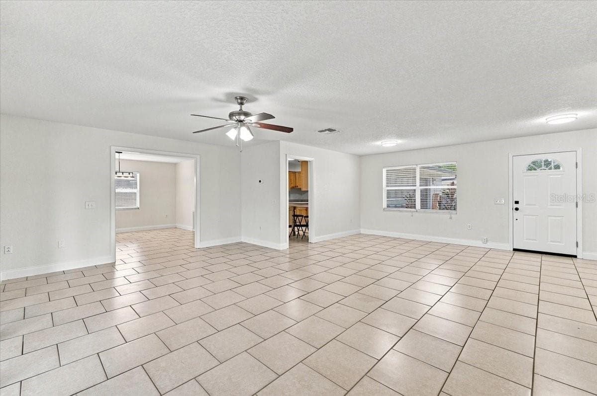 Living room with front door, entry to kitchen and dining room - 121 LOWELL RD, WINTER HAVEN