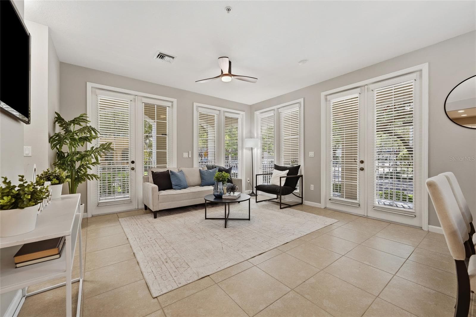 Corner-unit design provides exceptional natural light with multiple sets of French doors opening to the covered outdoor living areas. - 1674 LAKEMONT AVE #101, ORLANDO