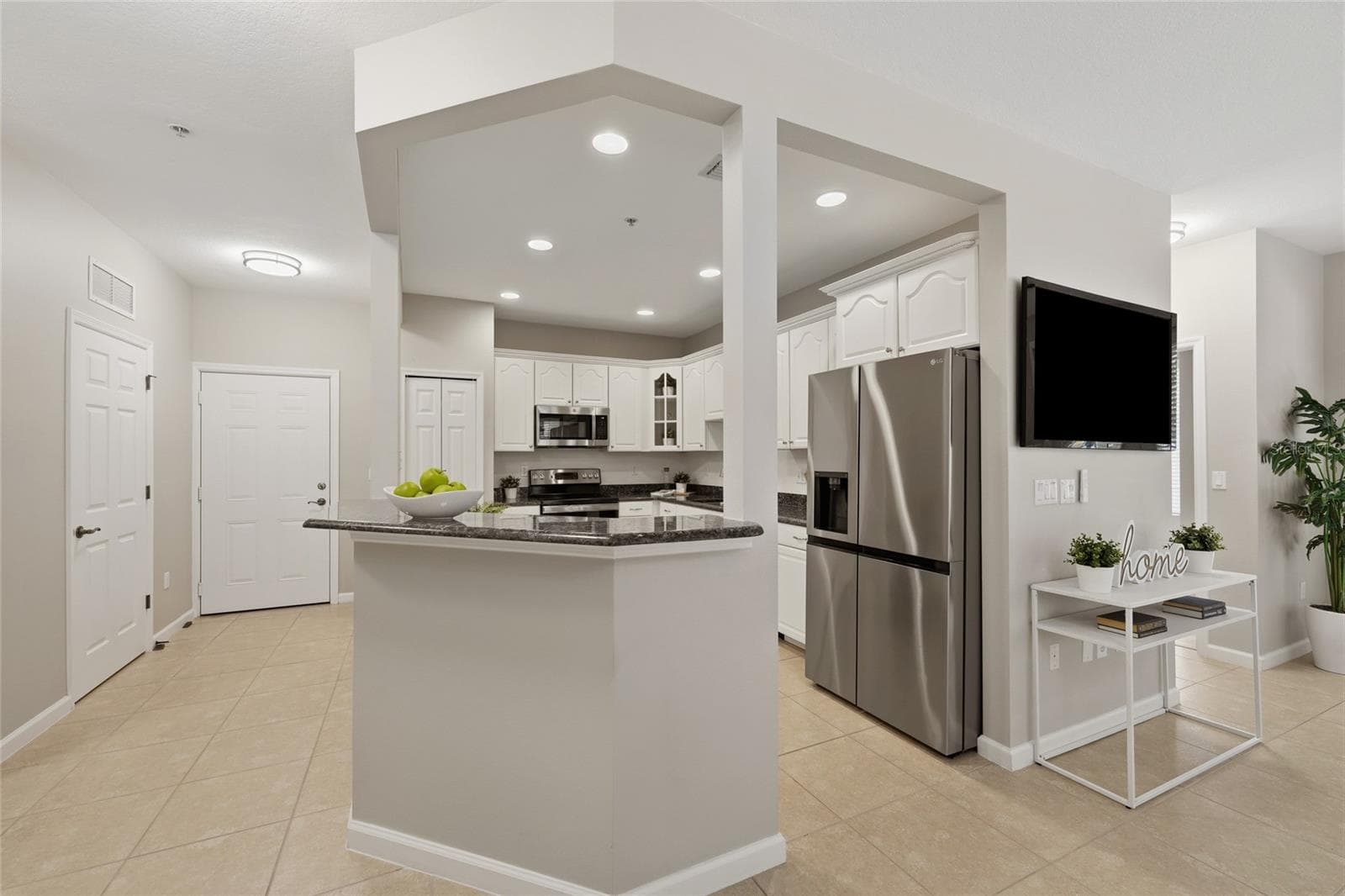 Spacious kitchen opens to the main living area and features generous cabinetry, granite countertops and stainless-steel appliances. - 1674 LAKEMONT AVE #101, ORLANDO