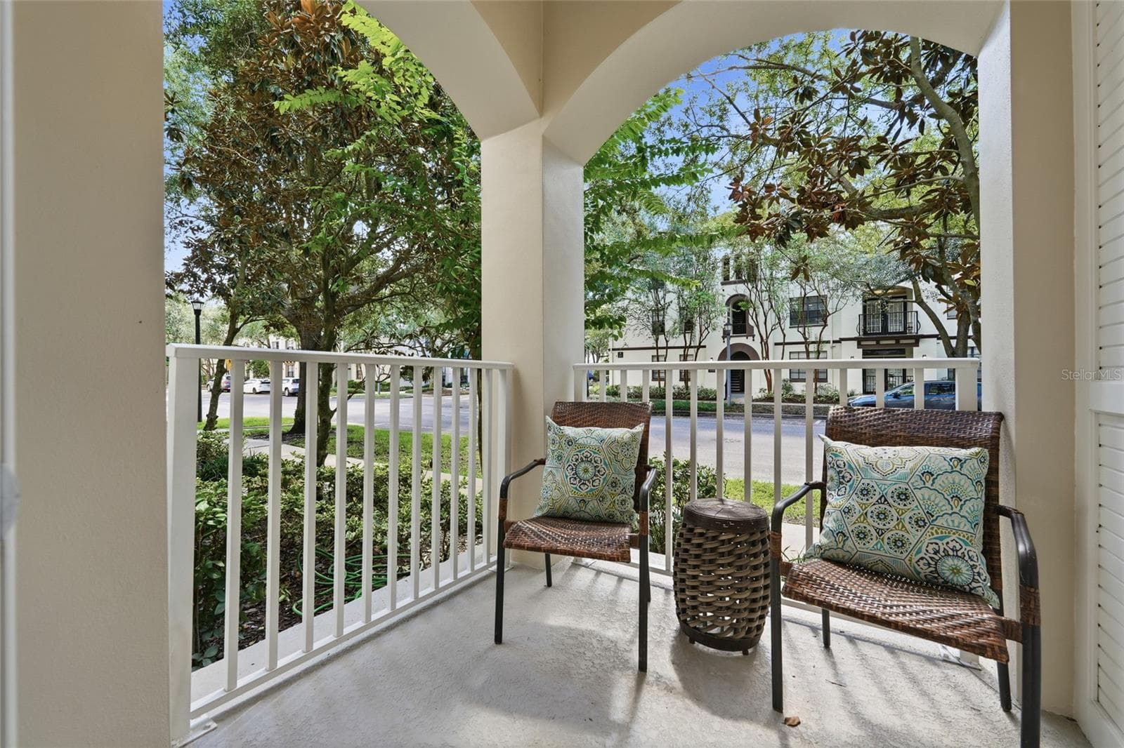 Private covered balcony off the primary suite offers a peaceful outdoor retreat surrounded by mature landscaping. - 1674 LAKEMONT AVE #101, ORLANDO