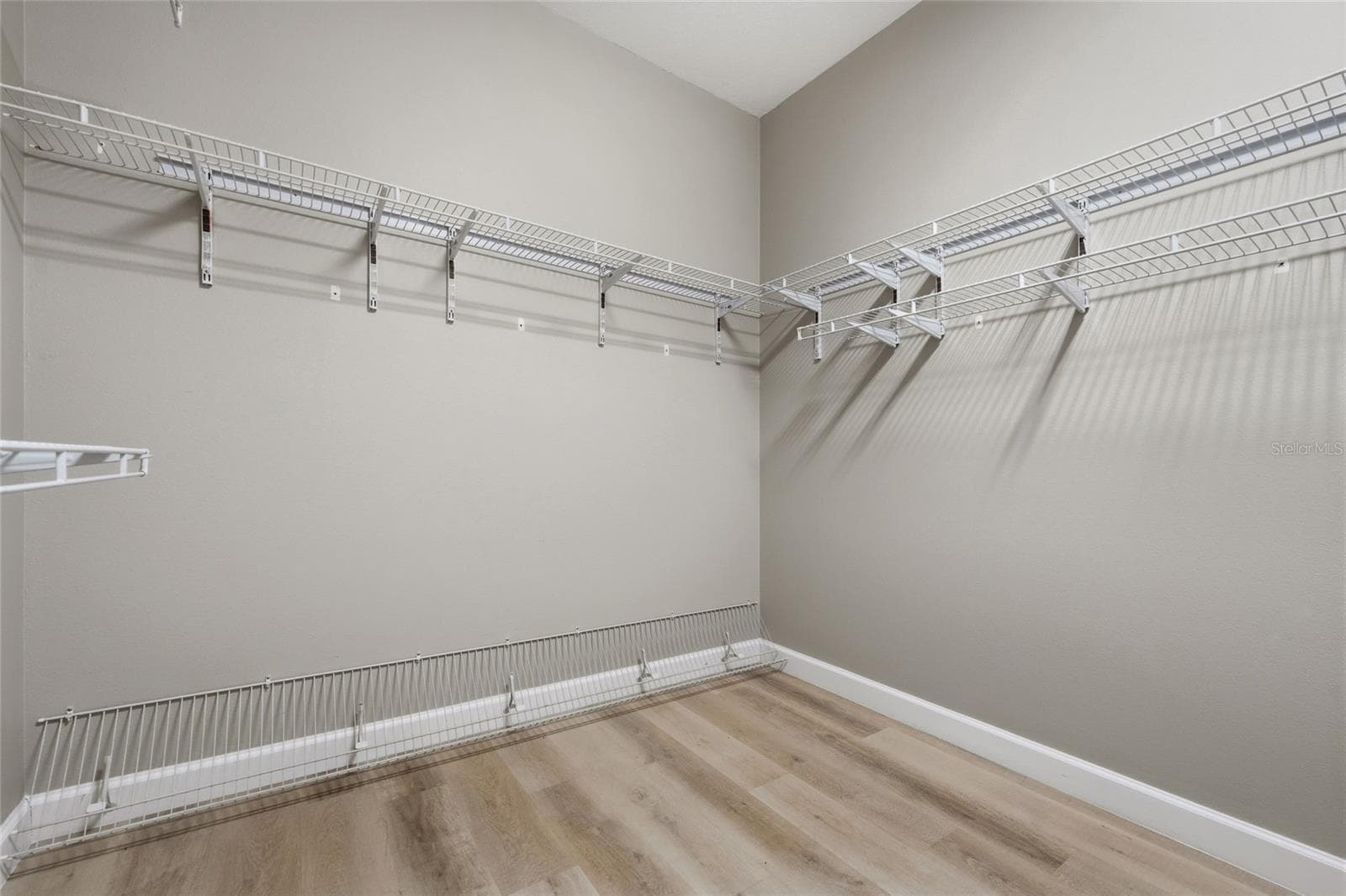 Large walk-in primary closet provides excellent storage with wraparound shelving. - 1674 LAKEMONT AVE #101, ORLANDO