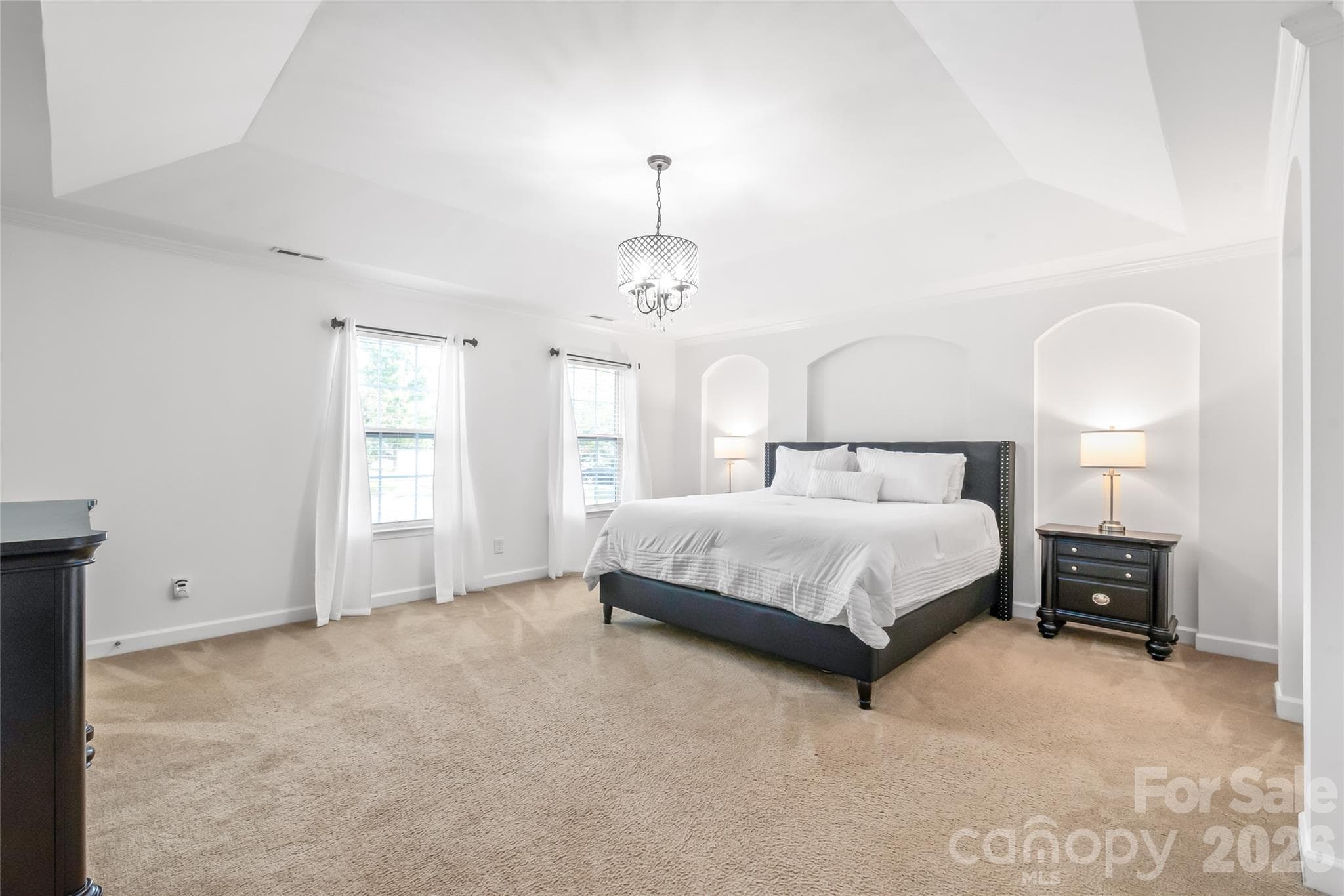 "A stunning primary bedroom featuring an elegant tray ceiling; a perfect retreat designed for relaxation and comfort." - 6404 Lanzerac Manor Drive, Charlotte