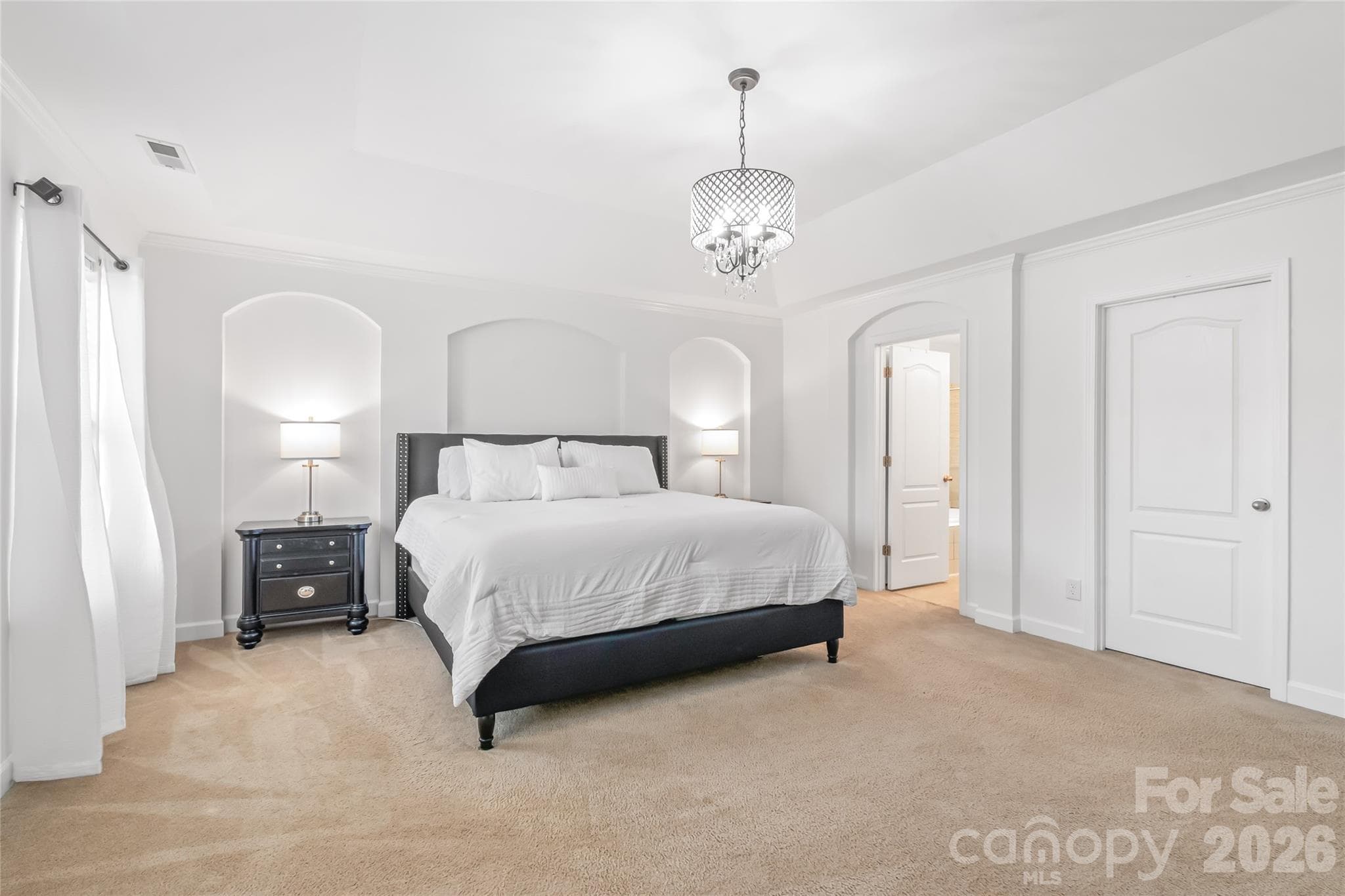 "Stunning primary bedroom featuring a gorgeous arched accent wall." - 6404 Lanzerac Manor Drive, Charlotte
