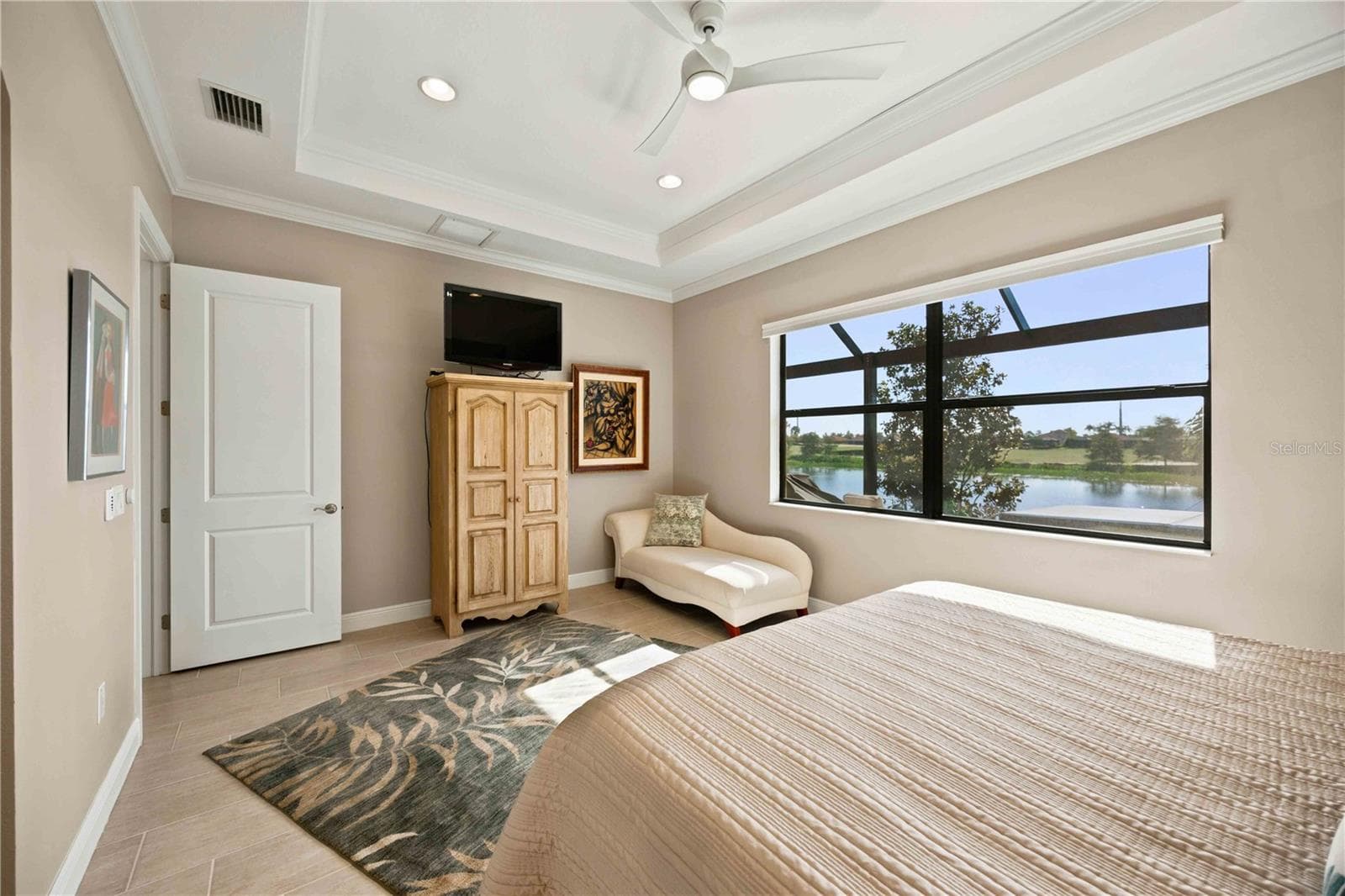 The primary bedroom is large and has lots of light overlooking the water - tile throughout. - 23709 WAVERLY CIR, VENICE