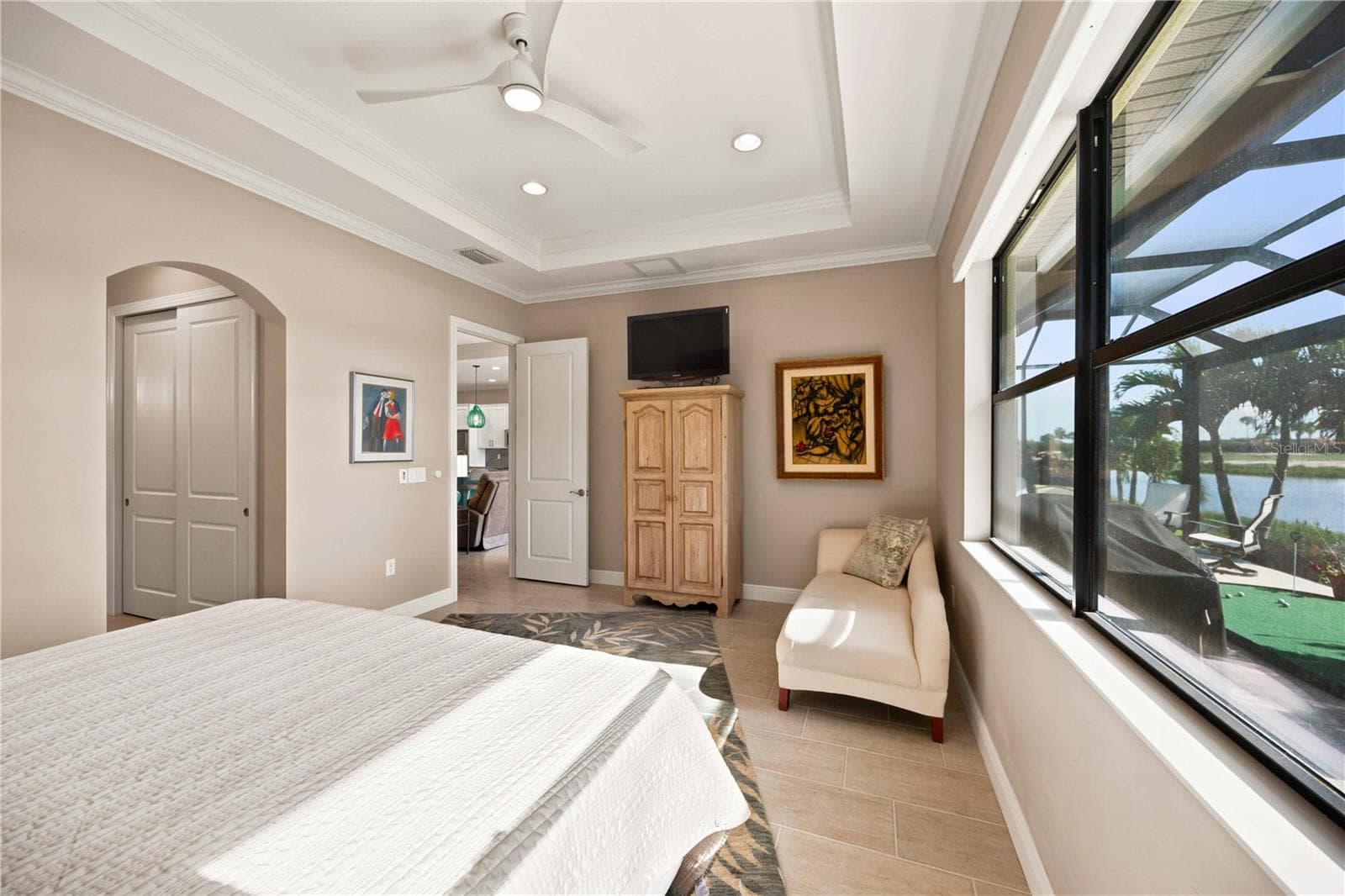 The primary bedroom is large and has lots of light overlooking the water - tile throughout. - 23709 WAVERLY CIR, VENICE