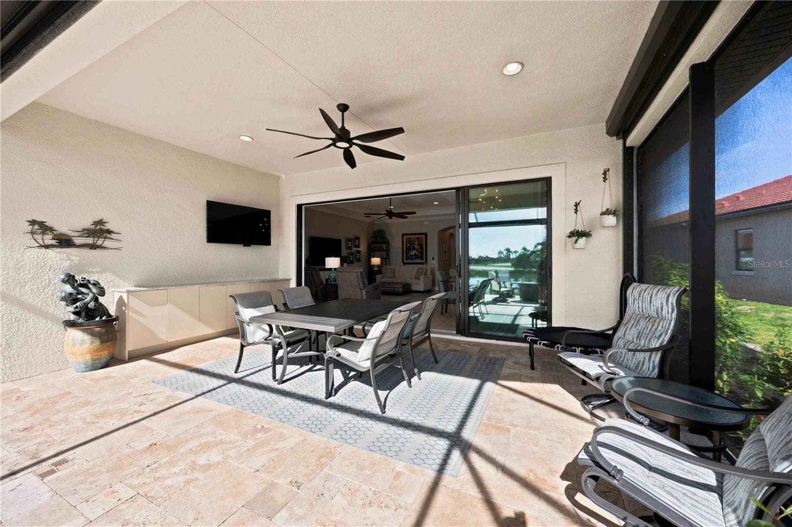 The travertine lanai is stunning.  A fabulous spot to relax. Extensive outdoor cabinets help keep you organized in the outdoor environment. - 23709 WAVERLY CIR, VENICE