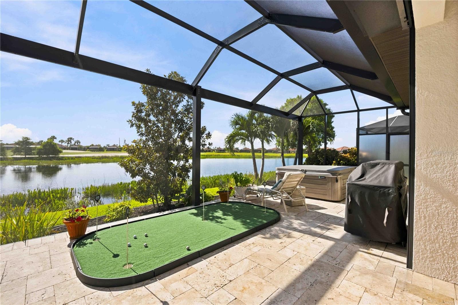 The travertine lanai is stunning.  A fabulous spot to relax. Extensive outdoor cabinets help keep you organized in the outdoor environment - 23709 WAVERLY CIR, VENICE