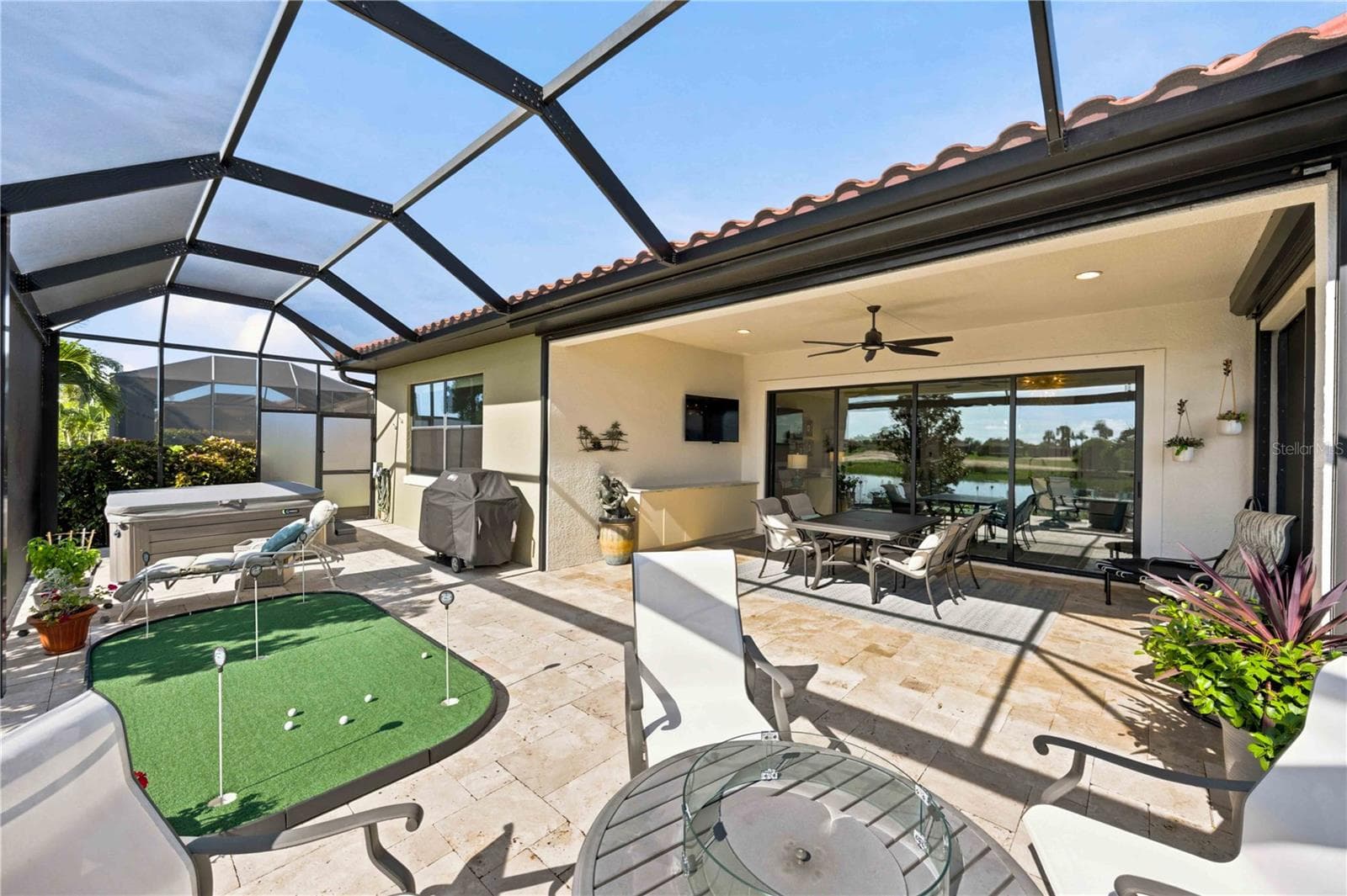 The travertine lanai is stunning.  A fabulous spot to relax. Extensive outdoor cabinets help keep you organized in the outdoor environment - 23709 WAVERLY CIR, VENICE