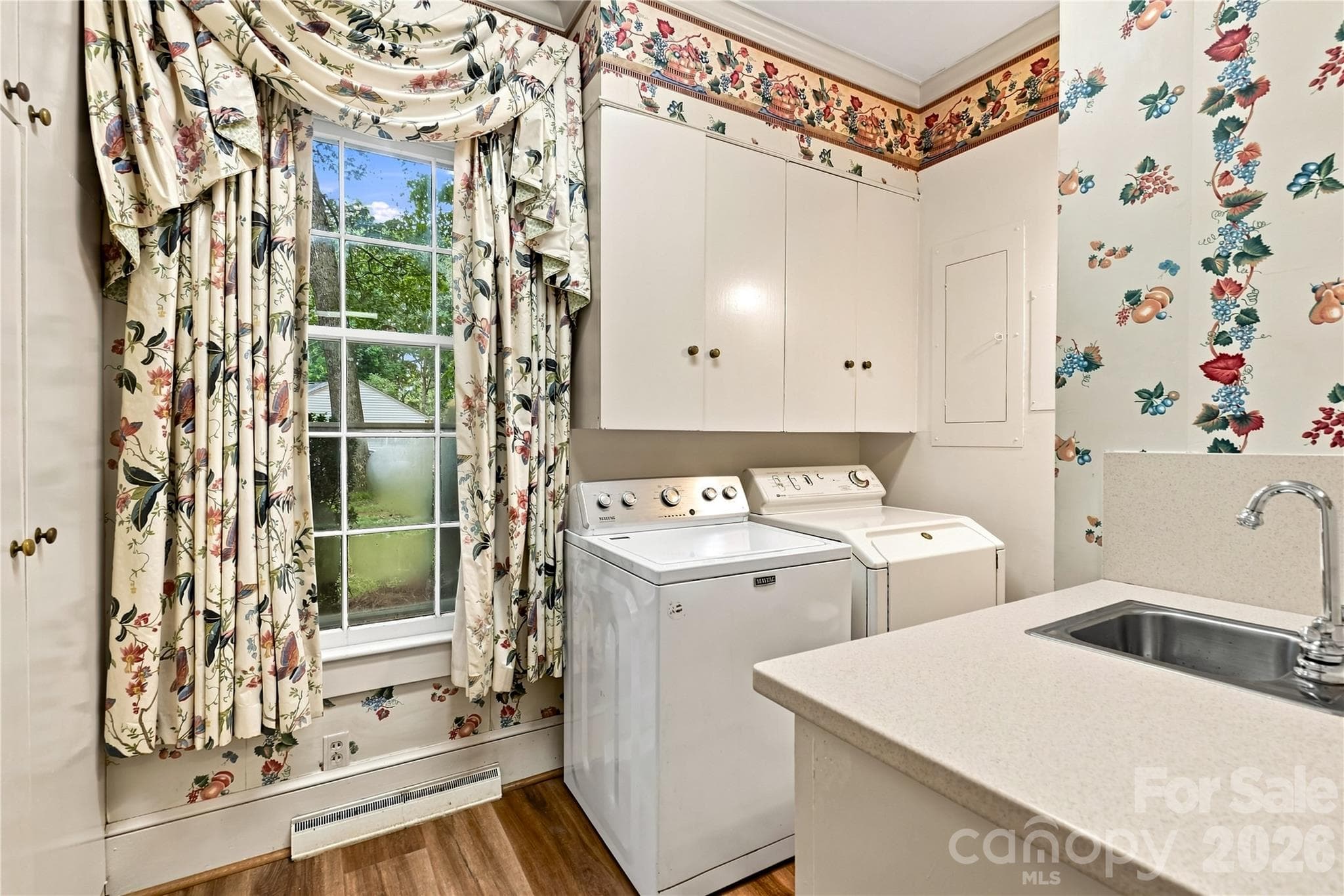 Main-level laundry room with cabinetry, sink and half bath. - 209 Labans Lane, Lincolnton