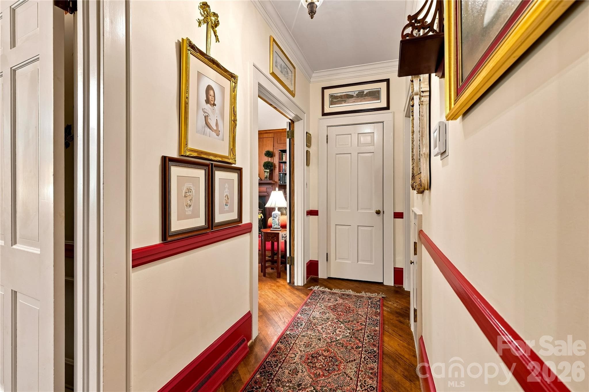 Main-level hallway with detailed trim and original hardwood flooring. - 209 Labans Lane, Lincolnton