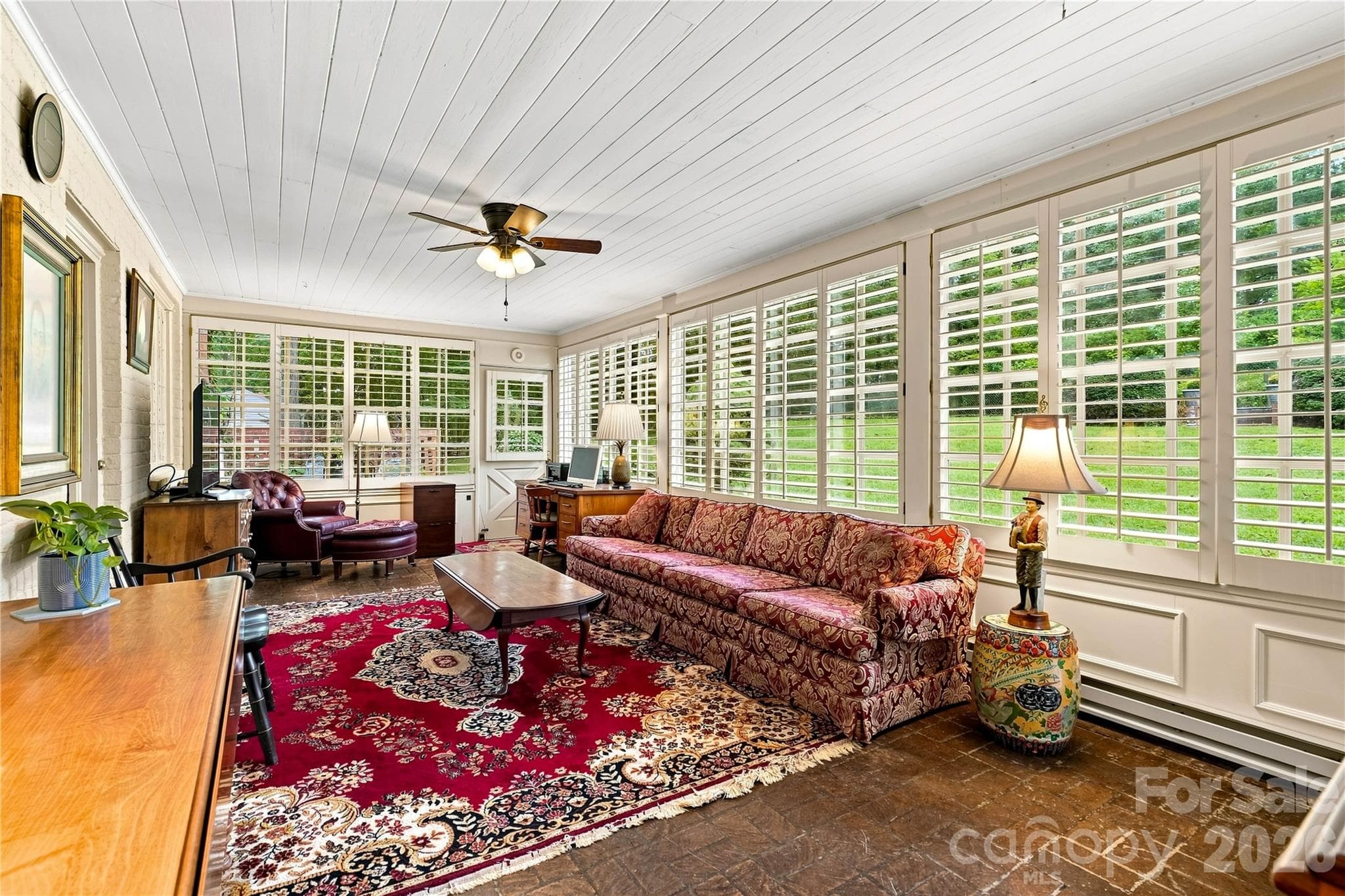 Sunroom surrounded by windows and plantation shutters. - 209 Labans Lane, Lincolnton