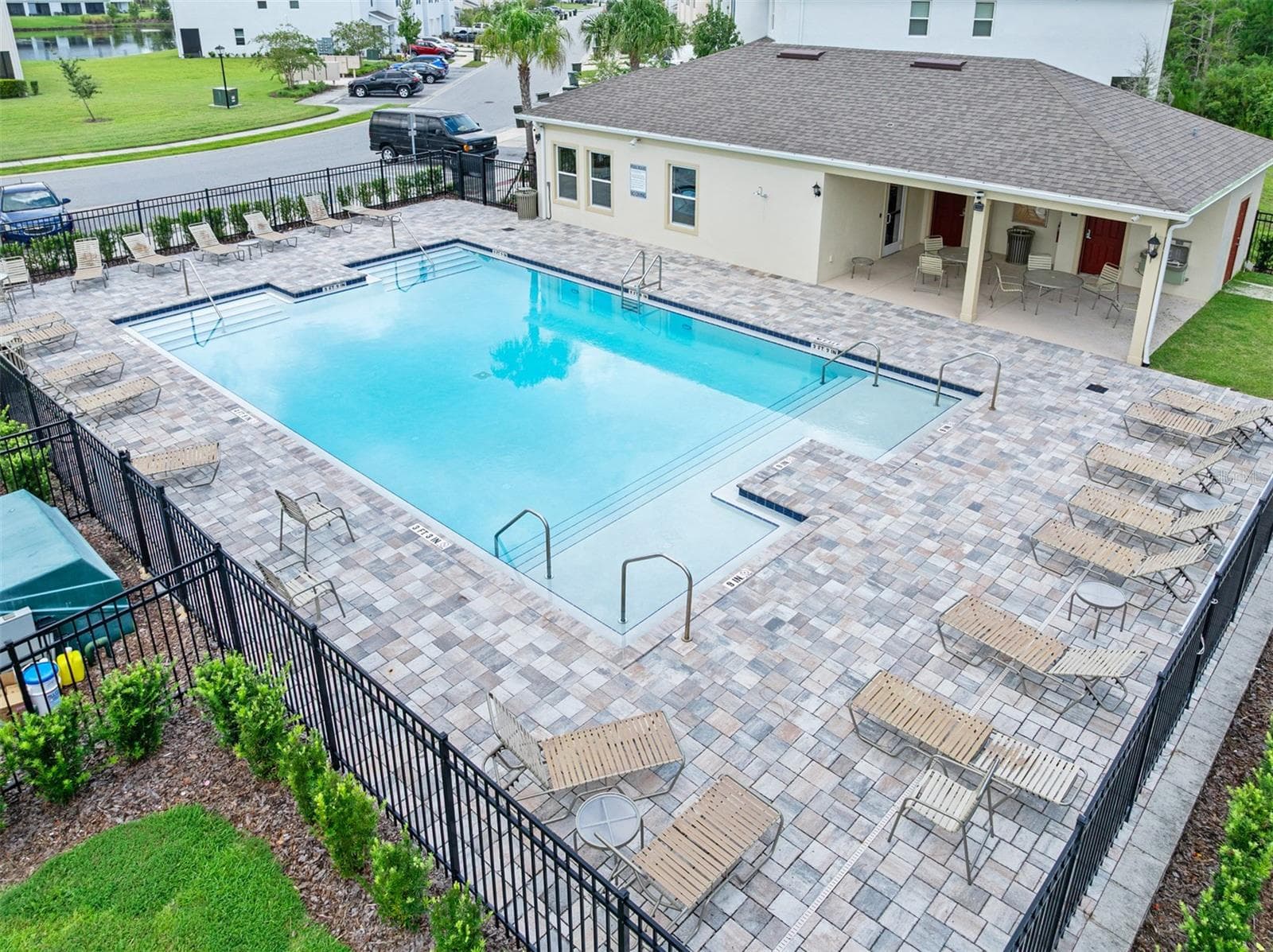 Community pool with lounge chairs and covered seating - 166 REENA DR, DAYTONA BEACH