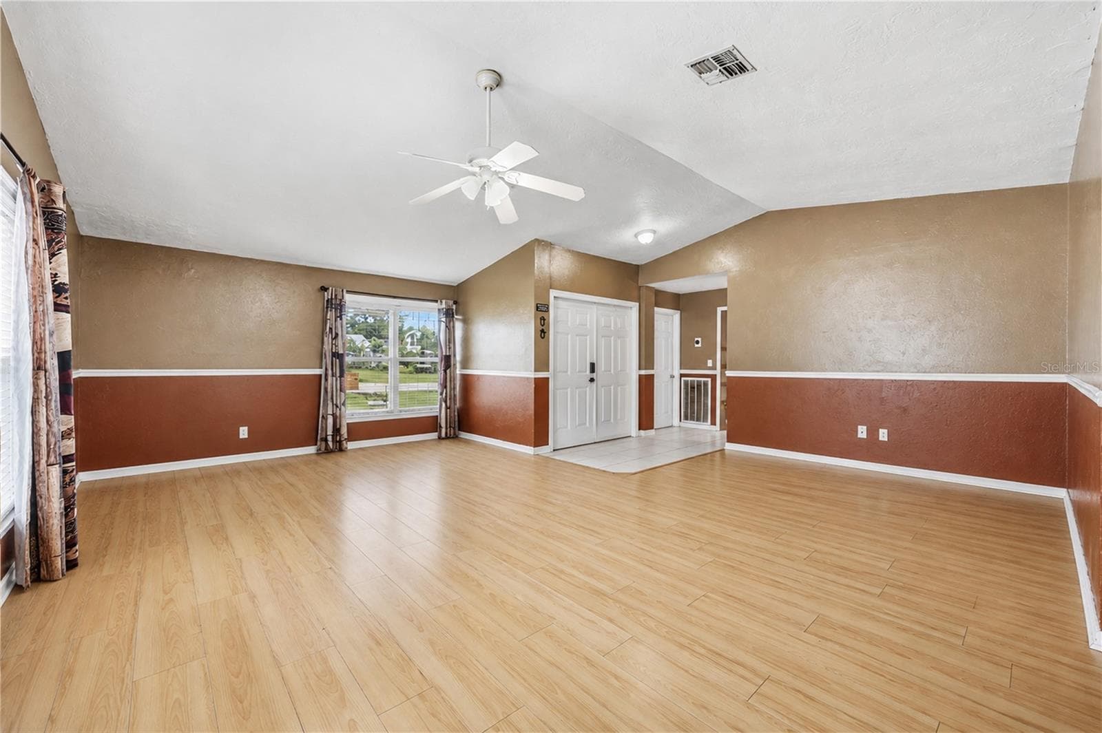 Additional view of the expansive main living area showcasing the open layout, foyer tile entry, and warm architectural details. - 3906 SANTIAGO ST, SEBRING